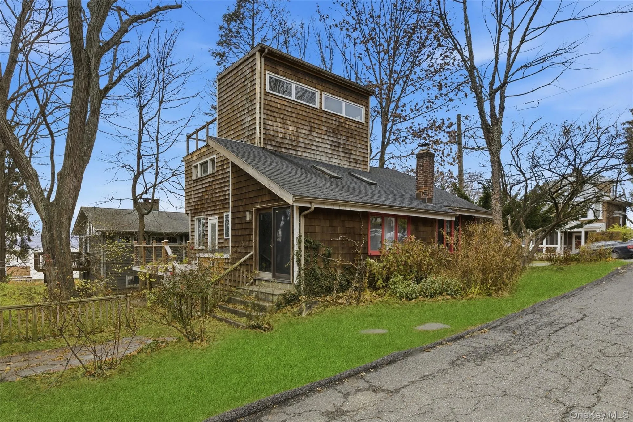 View of front facade featuring a shingled roof, a front yard, a chimney, and entry steps View of front facade featuring a shingled roof, a front yard, a chimney, and entry steps