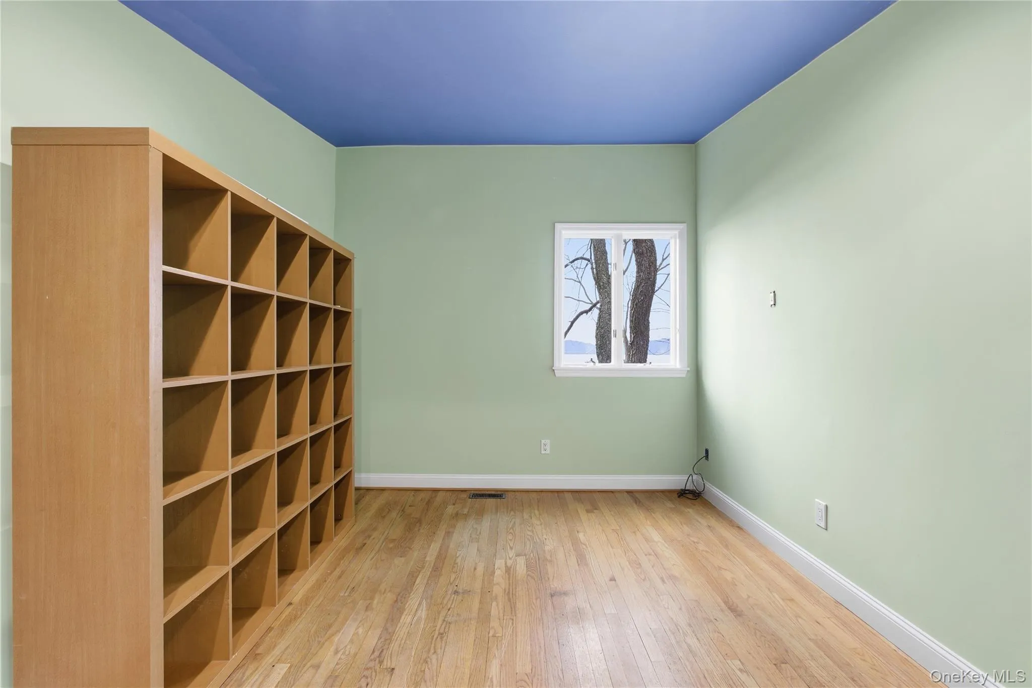 Spare room with light wood-style flooring and baseboards Spare room with light wood-style flooring and baseboards