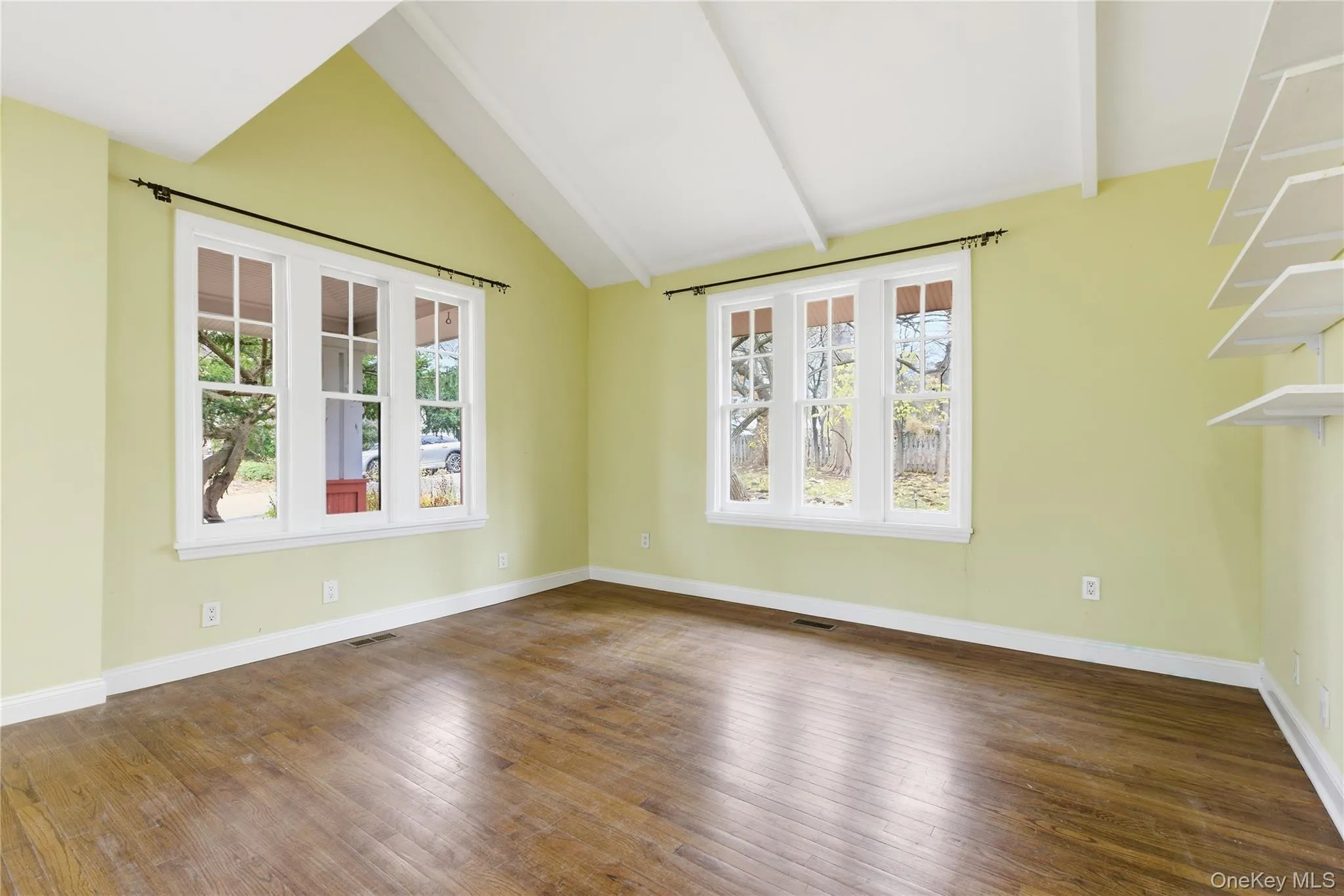 Unfurnished room with baseboards and dark wood-style floors Unfurnished room with baseboards and dark wood-style floors