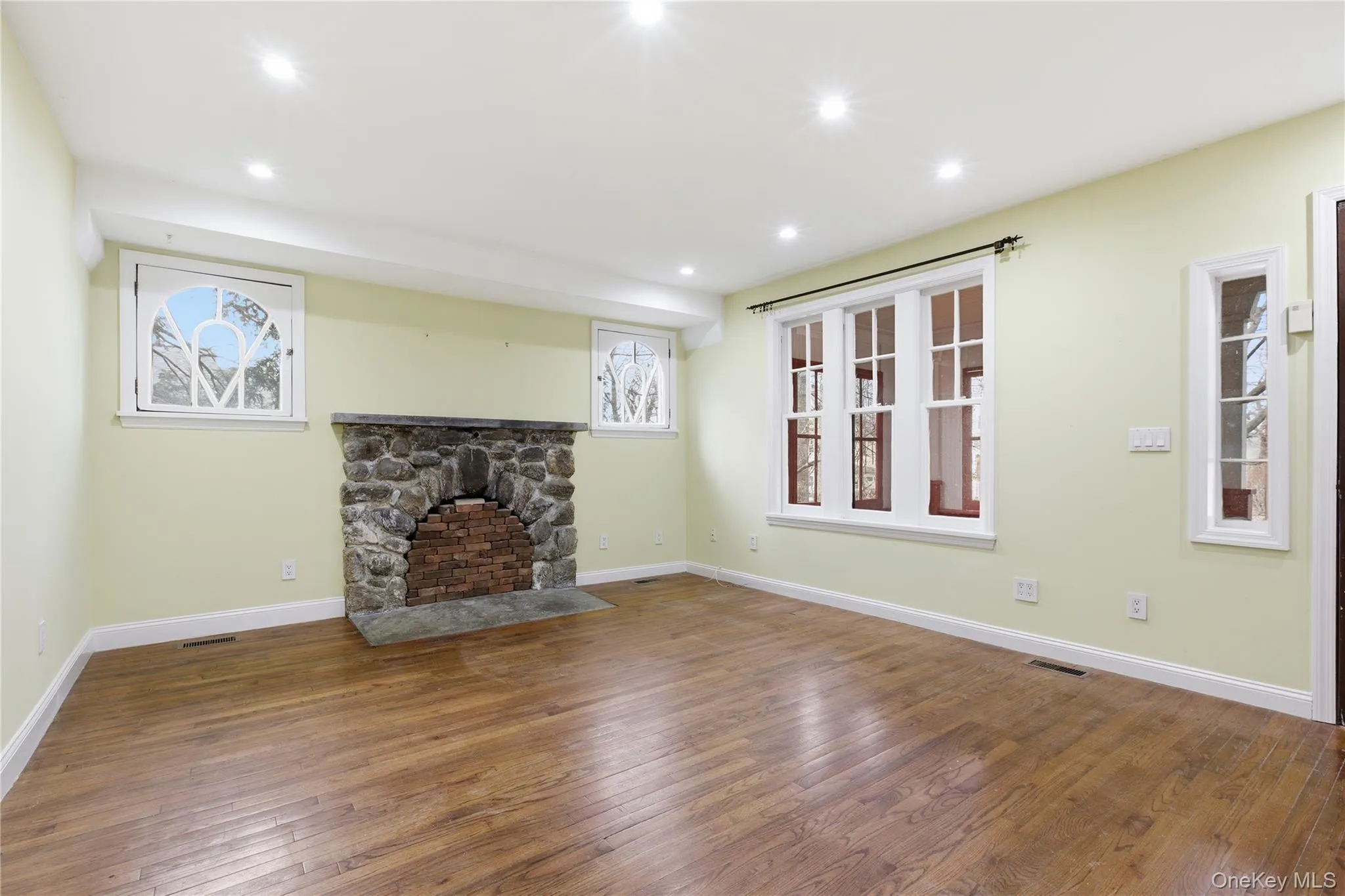 Unfurnished living room featuring dark wood-style flooring and recessed lighting Unfurnished living room featuring dark wood-style flooring and recessed lighting
