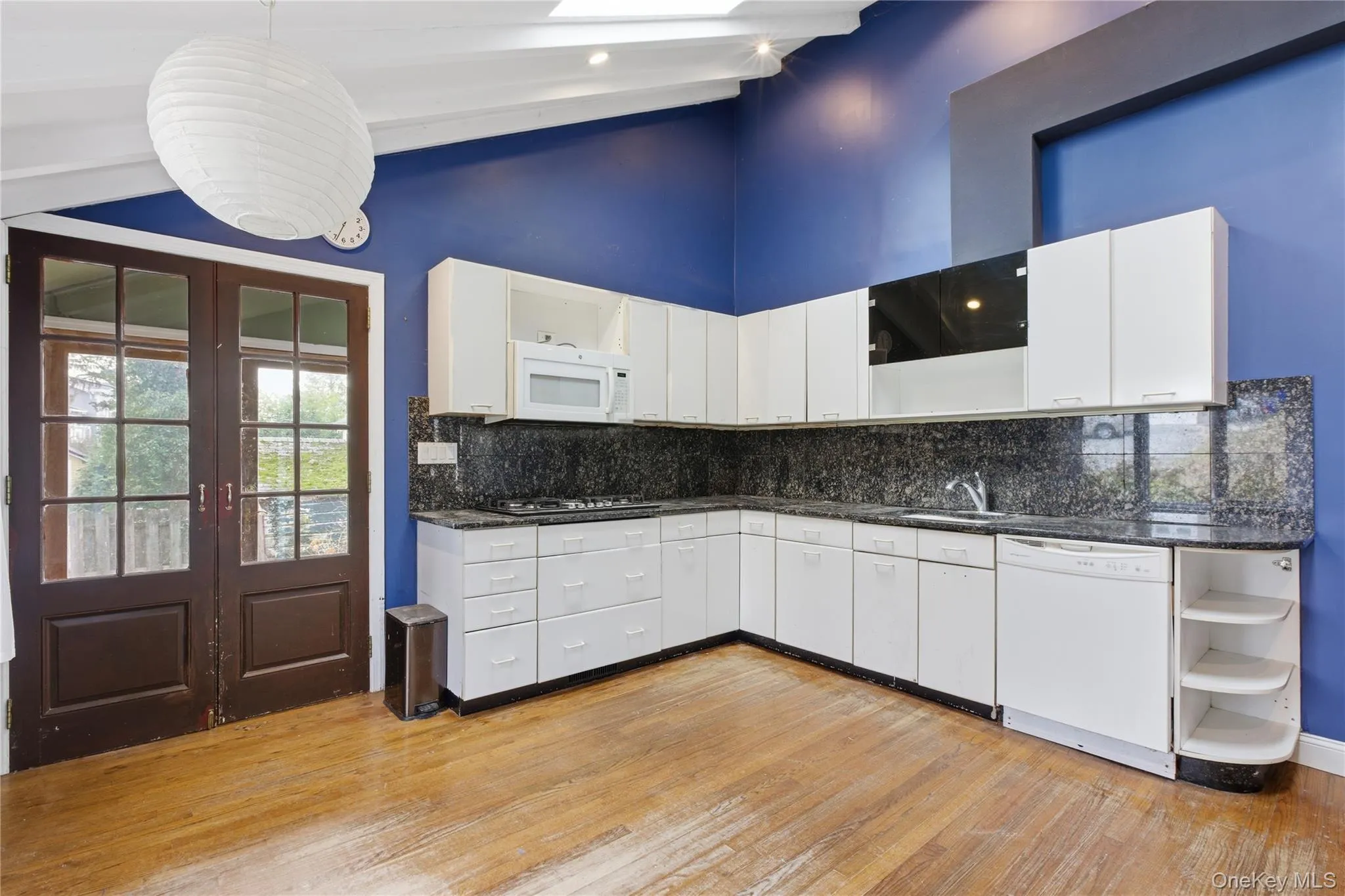 Kitchen with open shelves, french doors, white cabinets, white appliances, and hanging light fixtures Kitchen with open shelves, french doors, white cabinets, white appliances, and hanging light fixtures