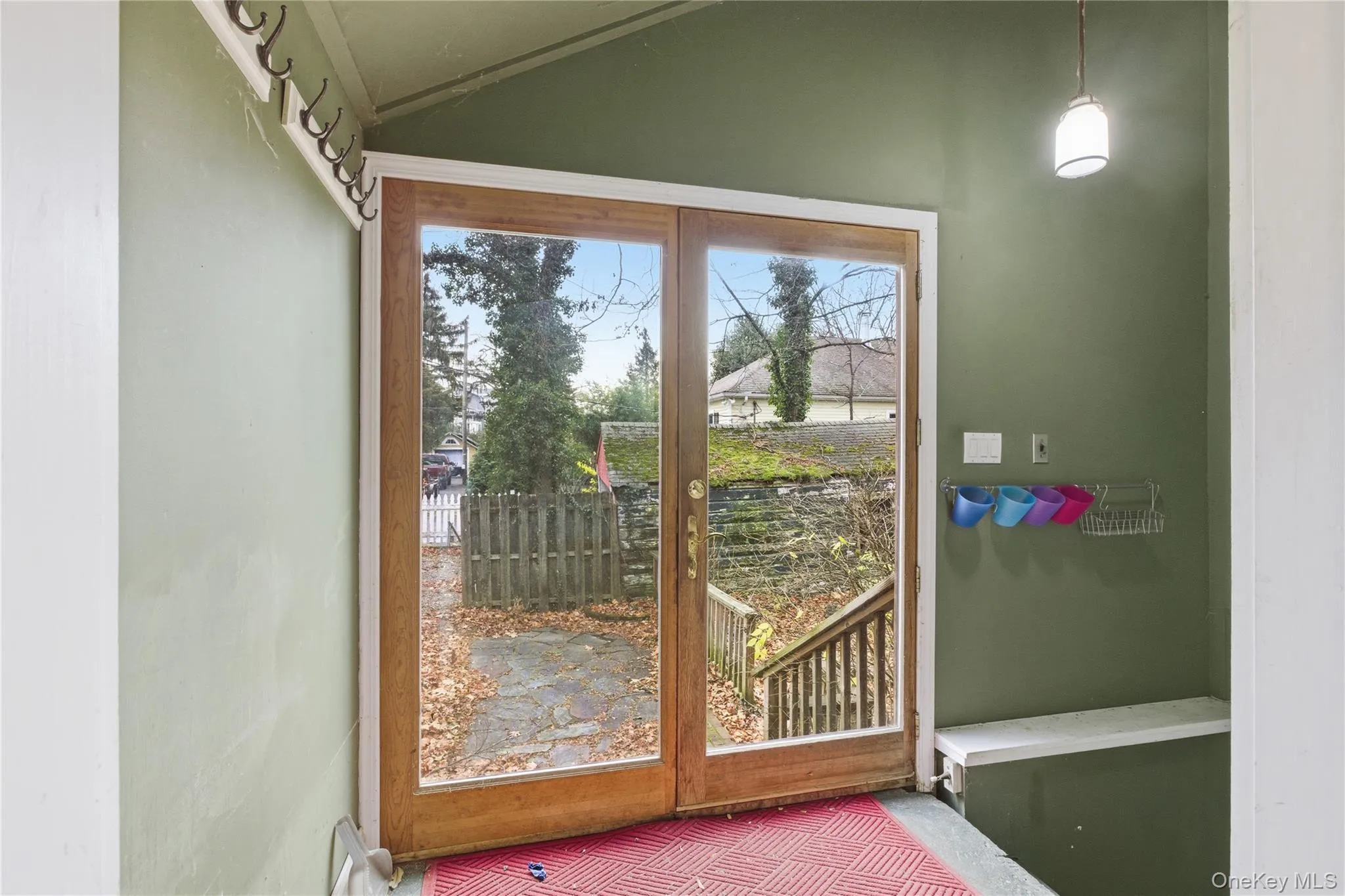 Doorway to outside featuring vaulted ceiling and carpet Doorway to outside featuring vaulted ceiling and carpet