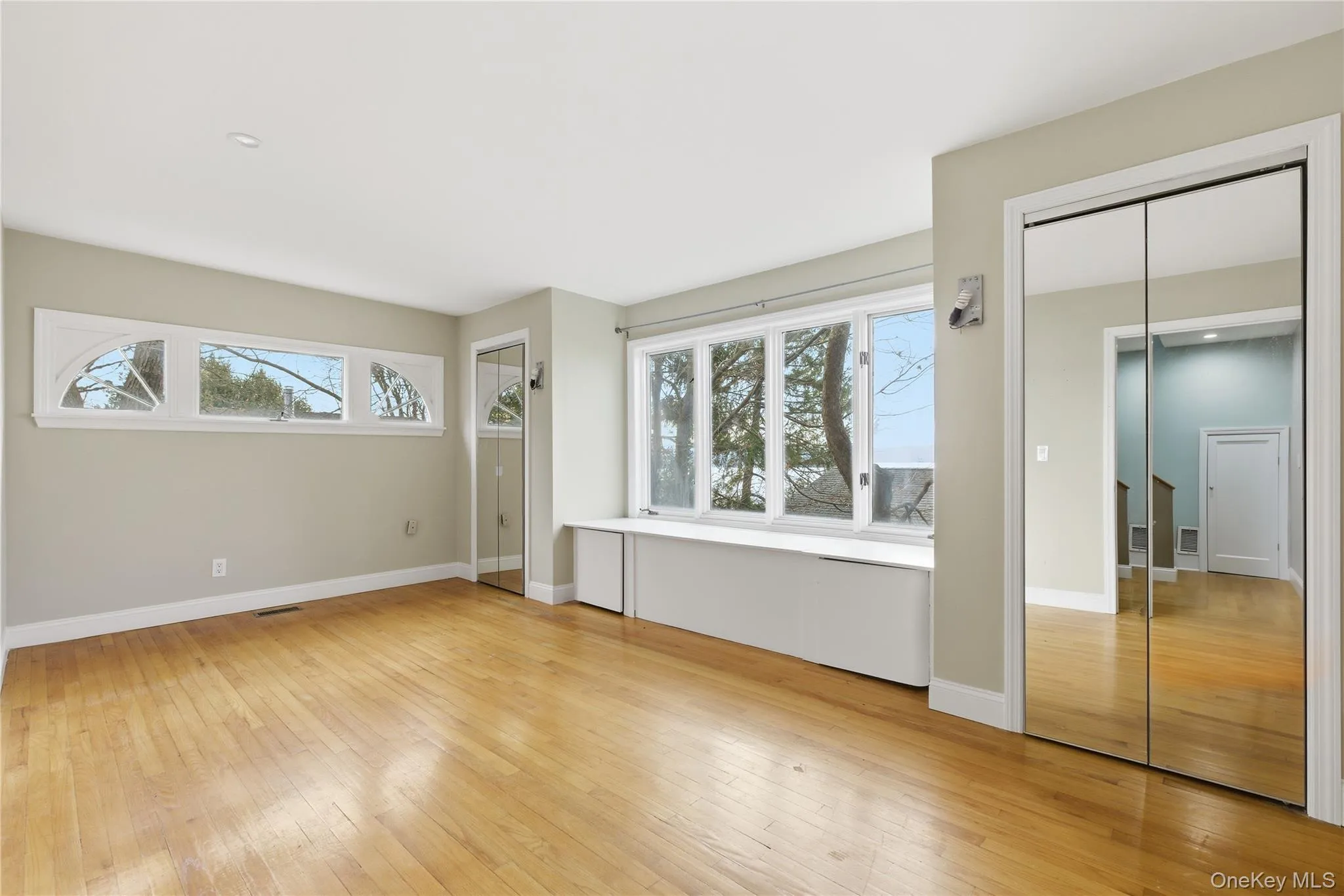 Unfurnished bedroom featuring two closets and light wood-style floors Unfurnished bedroom featuring two closets and light wood-style floors
