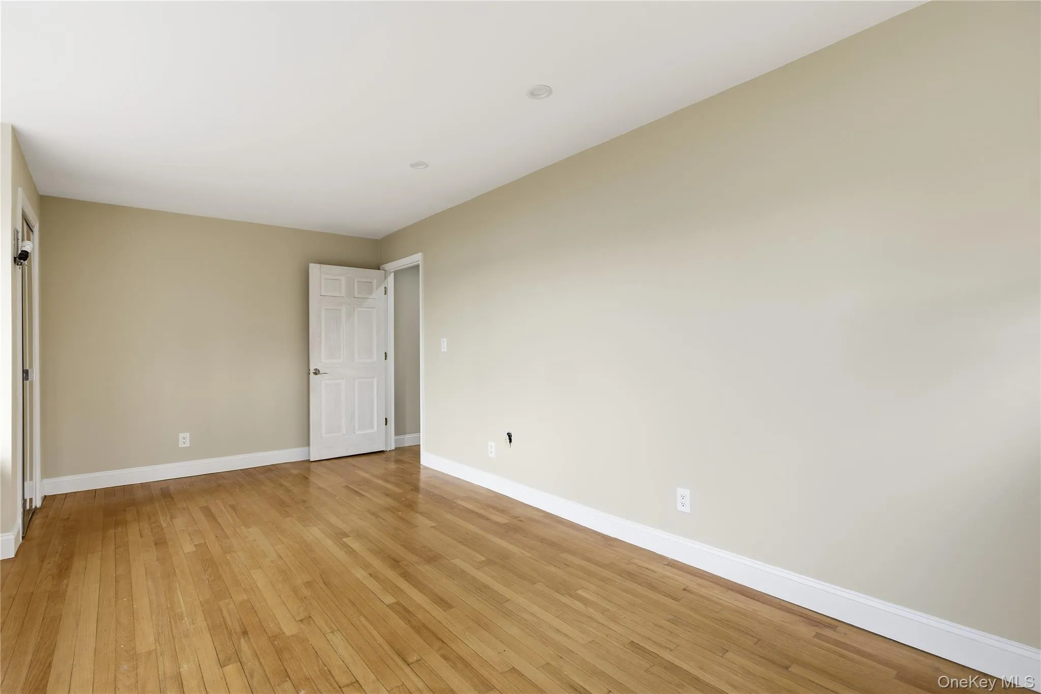 Spare room with light wood finished floors and baseboards Spare room with light wood finished floors and baseboards