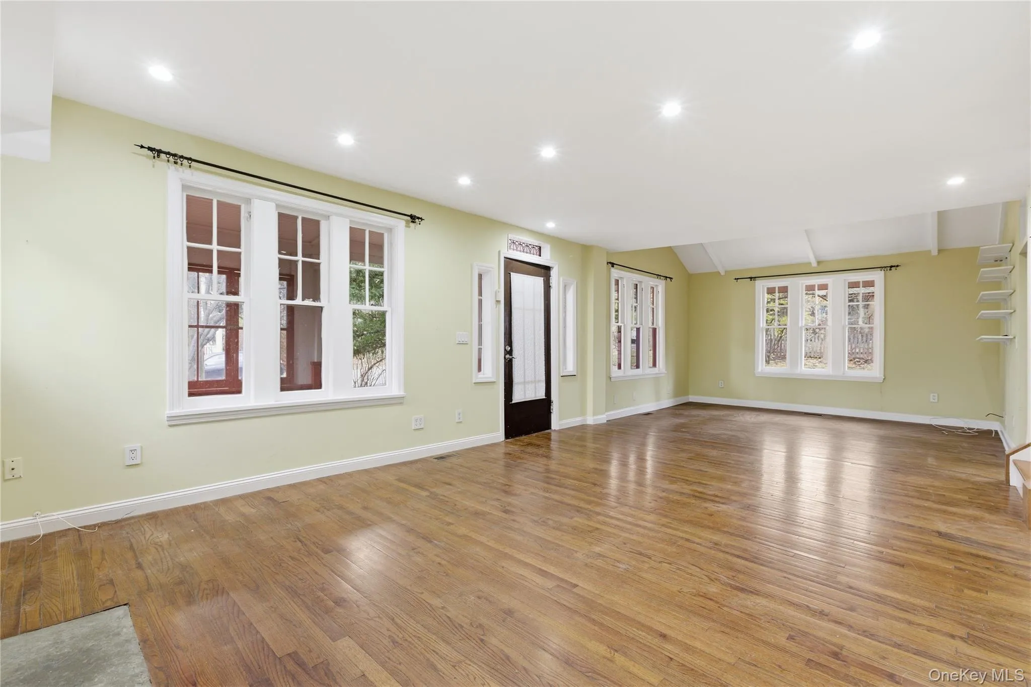 Unfurnished living room with light wood-style flooring, recessed lighting, and lofted ceiling Unfurnished living room with light wood-style flooring, recessed lighting, and lofted ceiling