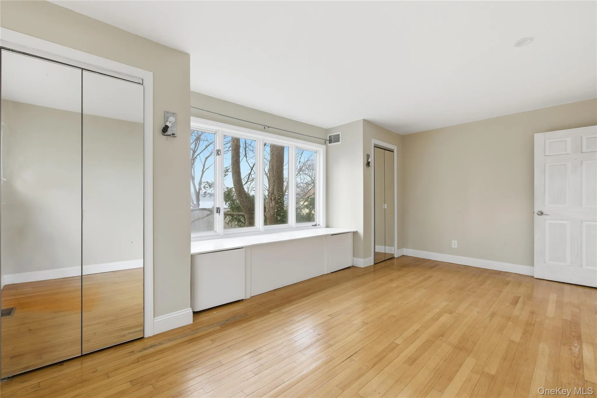 Unfurnished bedroom featuring two closets and light wood-type flooring Unfurnished bedroom featuring two closets and light wood-type flooring