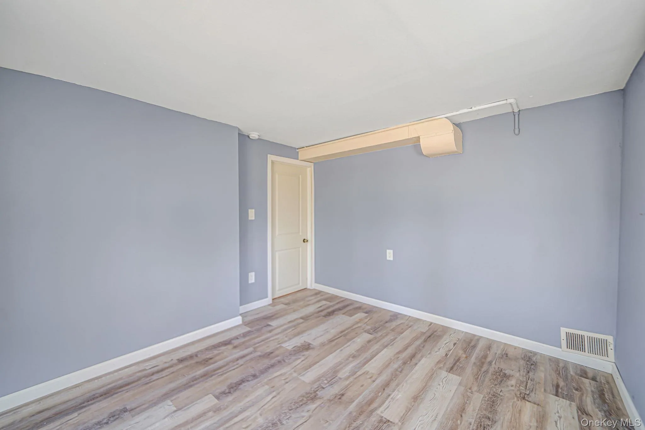 Empty room featuring light wood-type flooring and baseboards Empty room featuring light wood-type flooring and baseboards