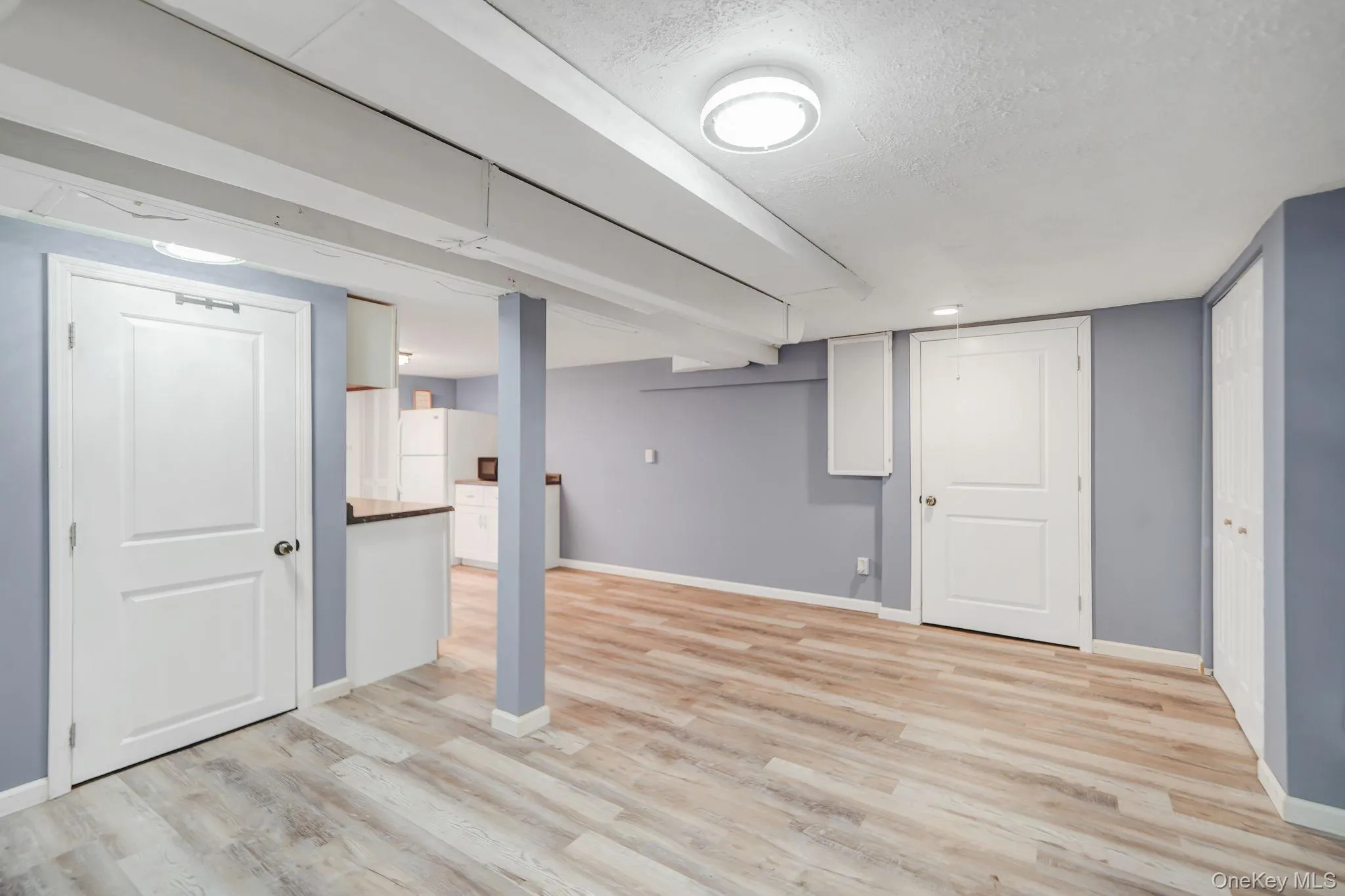 Finished basement with a textured ceiling and light wood-style floors Finished basement with a textured ceiling and light wood-style floors