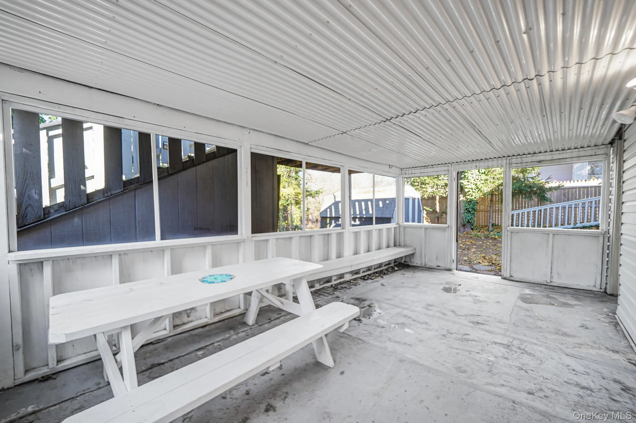 View of patio / terrace featuring a sunroom and outdoor dining space View of patio / terrace featuring a sunroom and outdoor dining space