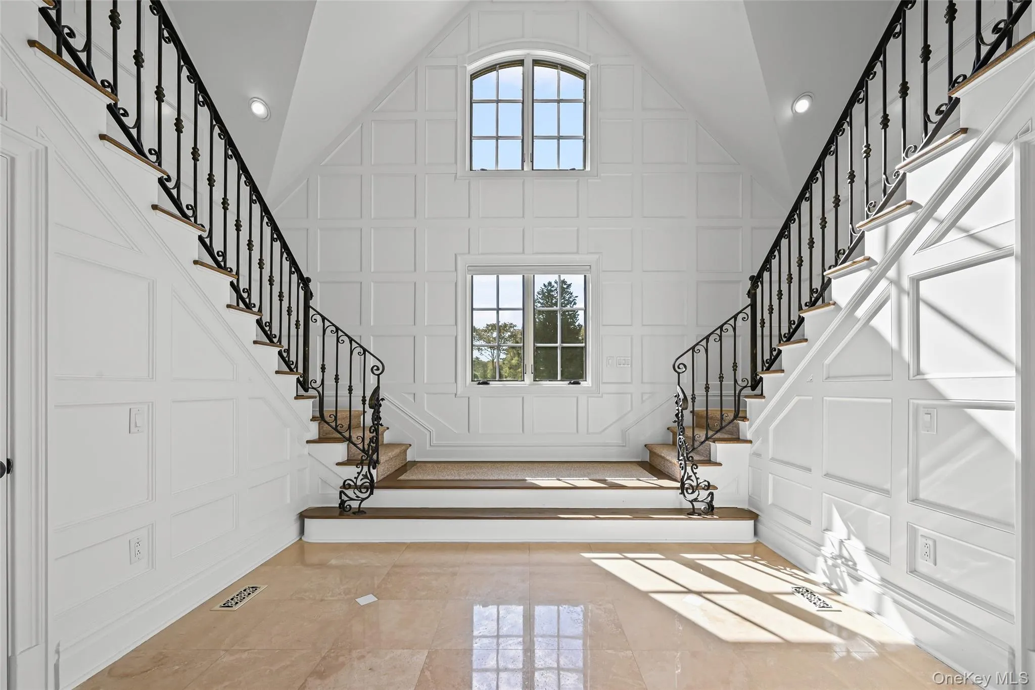 Entryway featuring a decorative wall, stairs, and high vaulted ceiling Entryway featuring a decorative wall, stairs, and high vaulted ceiling