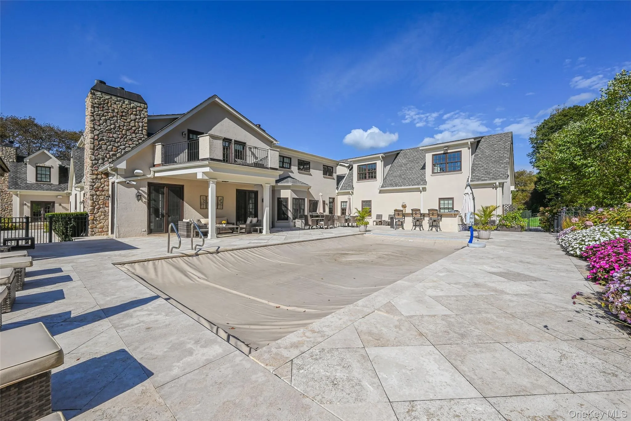 Rear view of property featuring a patio, a balcony, a chimney, and stucco siding Rear view of property featuring a patio, a balcony, a chimney, and stucco siding