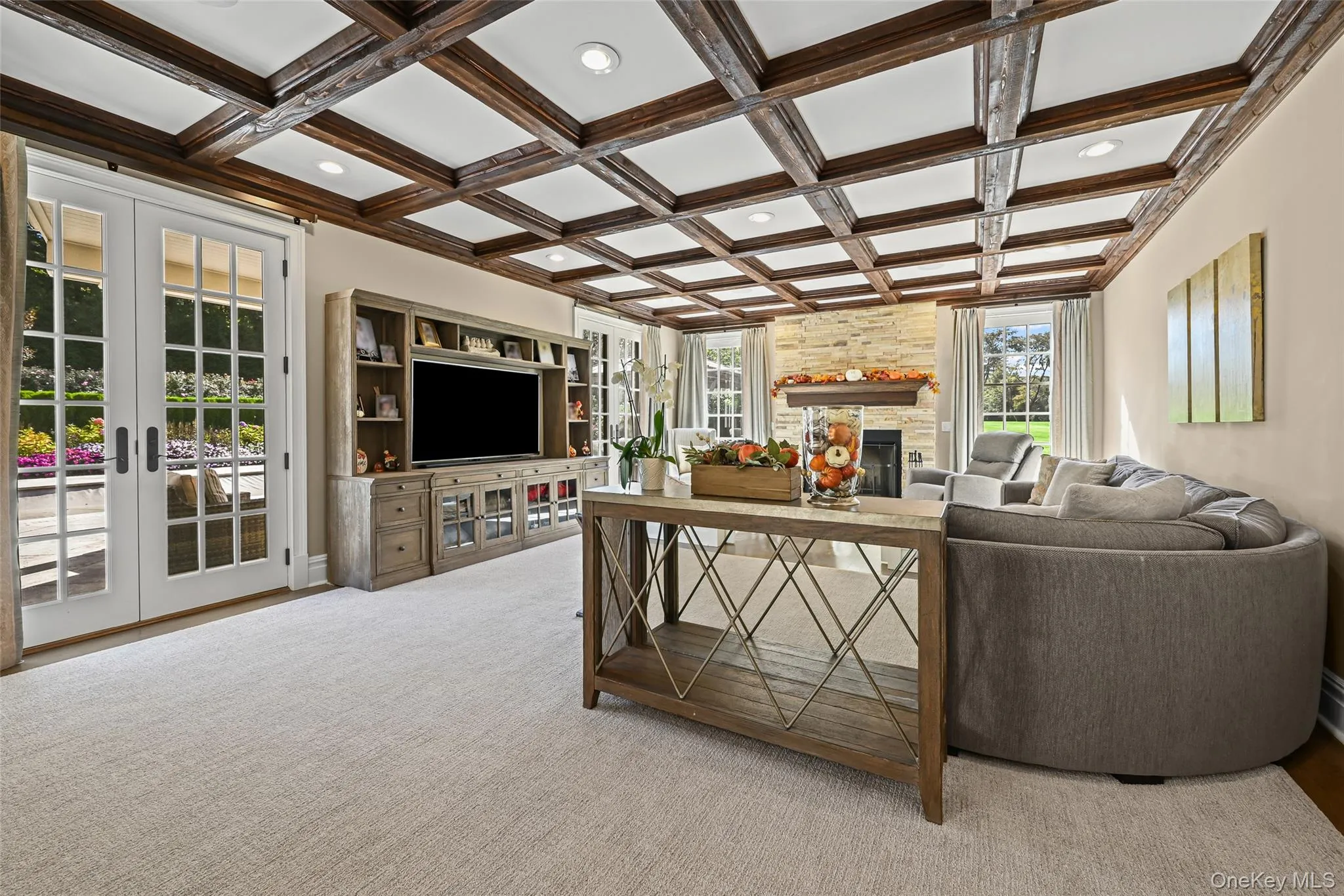 Living area with a stone fireplace, coffered ceiling, french doors, recessed lighting, and beamed ceiling Living area with a stone fireplace, coffered ceiling, french doors, recessed lighting, and beamed ceiling