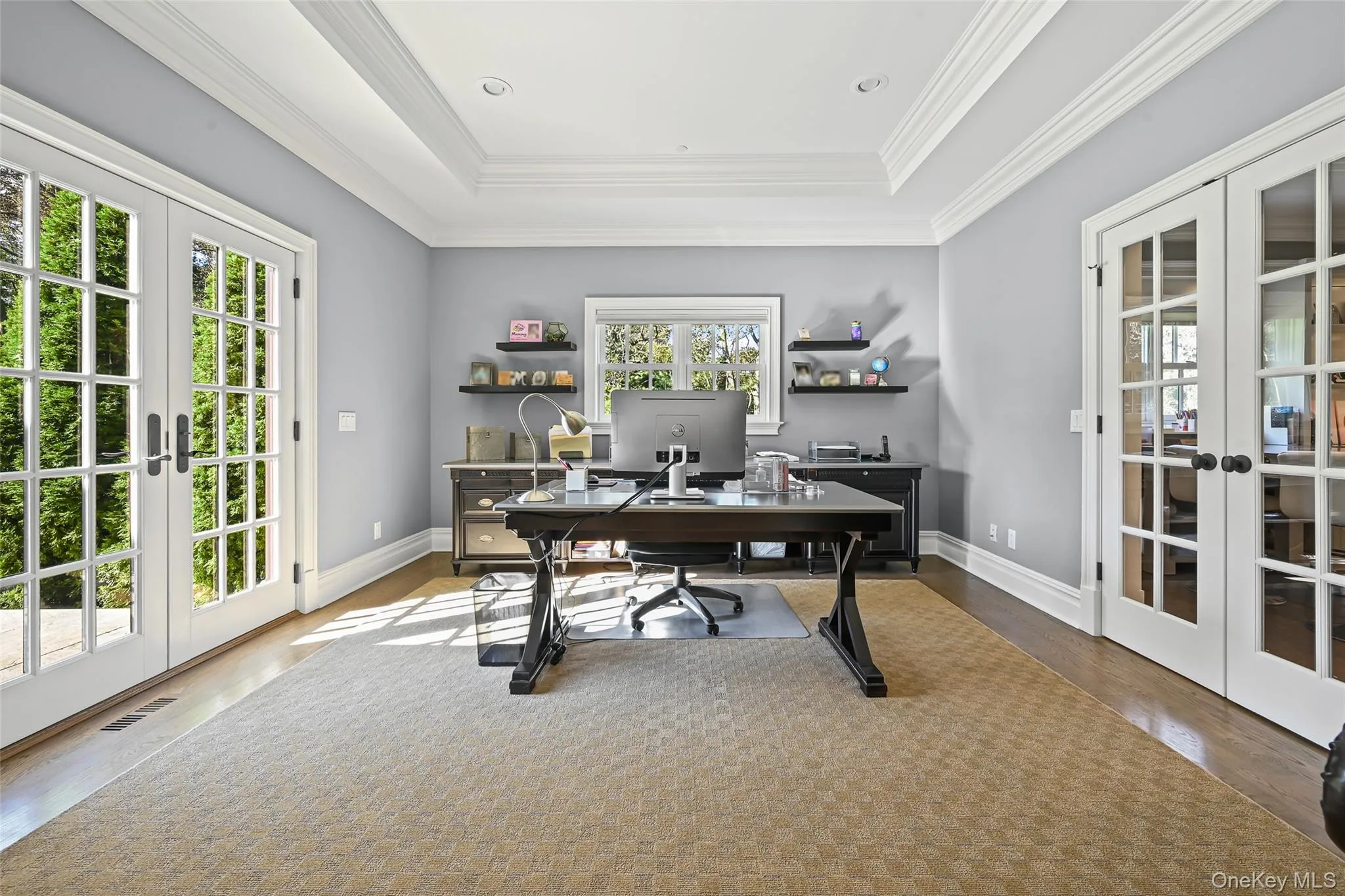 Office space featuring french doors, wood finished floors, a tray ceiling, and crown molding Office space featuring french doors, wood finished floors, a tray ceiling, and crown molding