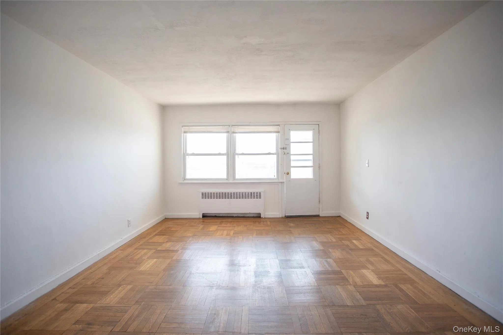 Empty room with radiator and baseboards Empty room with radiator and baseboards