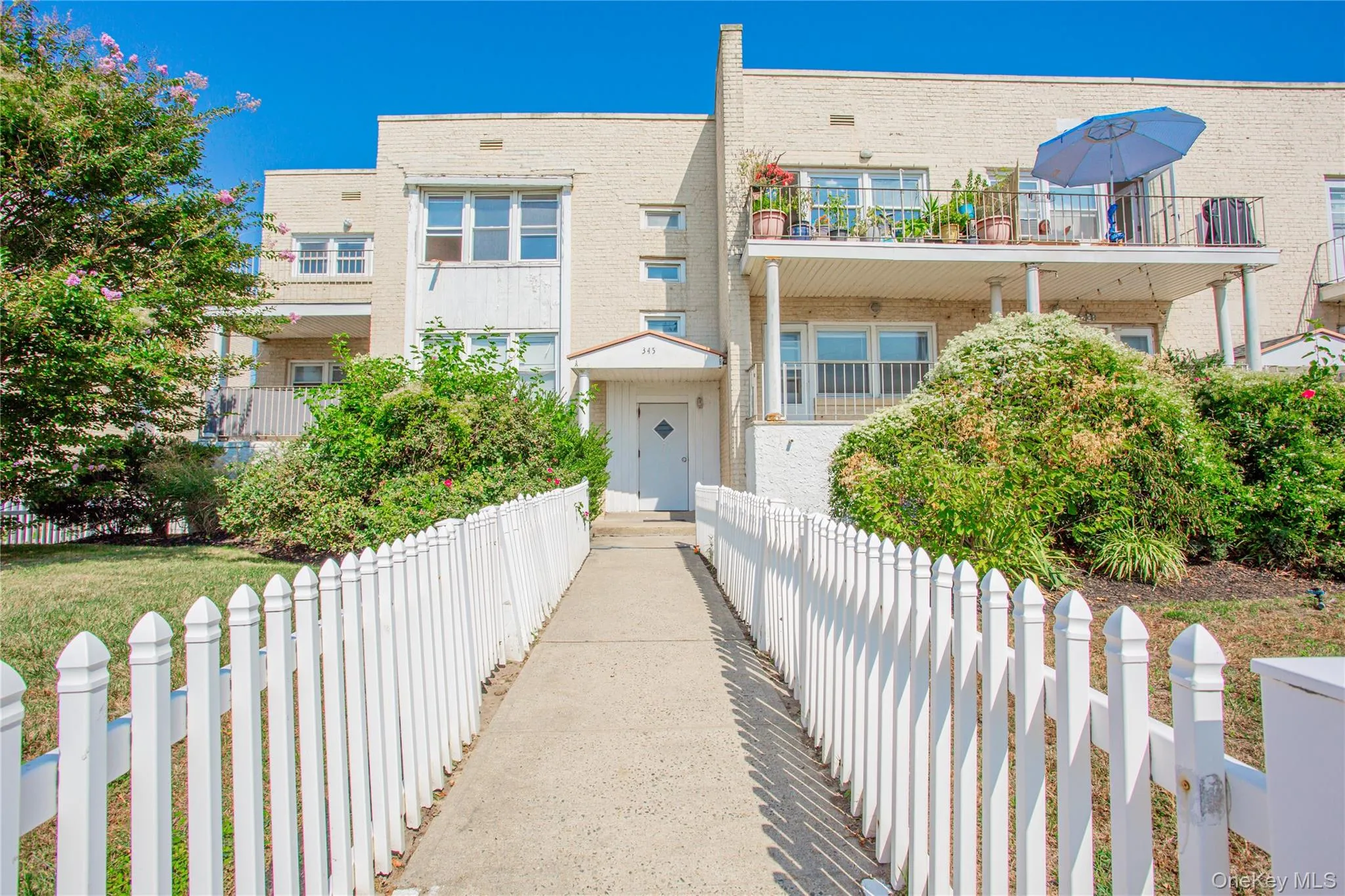 View of front of property with brick siding and a balcony View of front of property with brick siding and a balcony