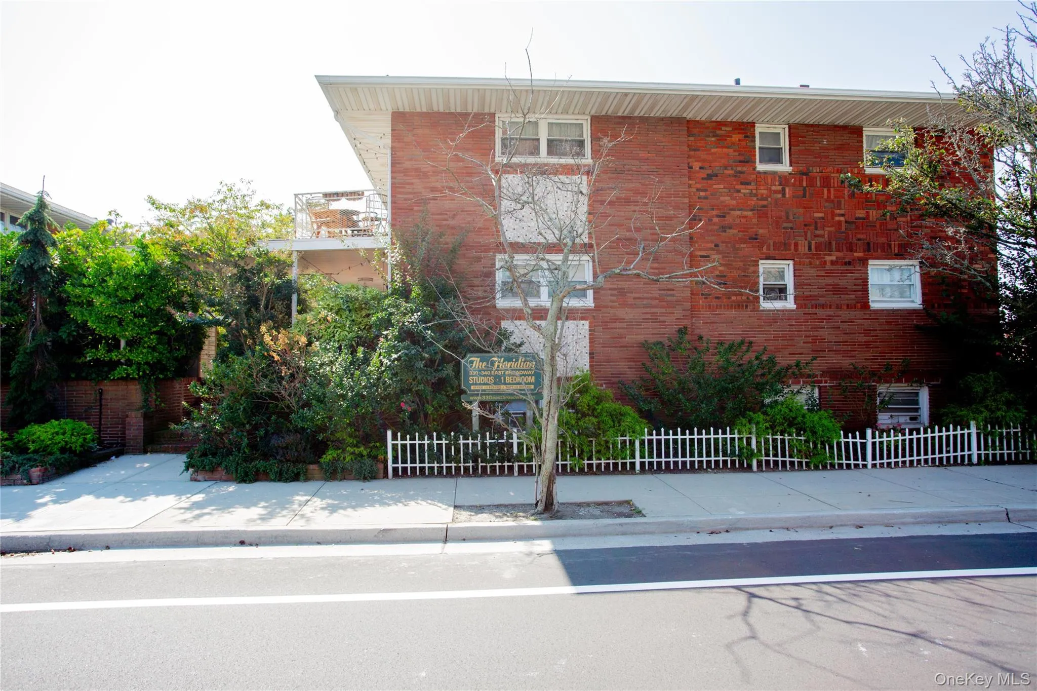 View of front of property featuring a balcony and brick siding View of front of property featuring a balcony and brick siding
