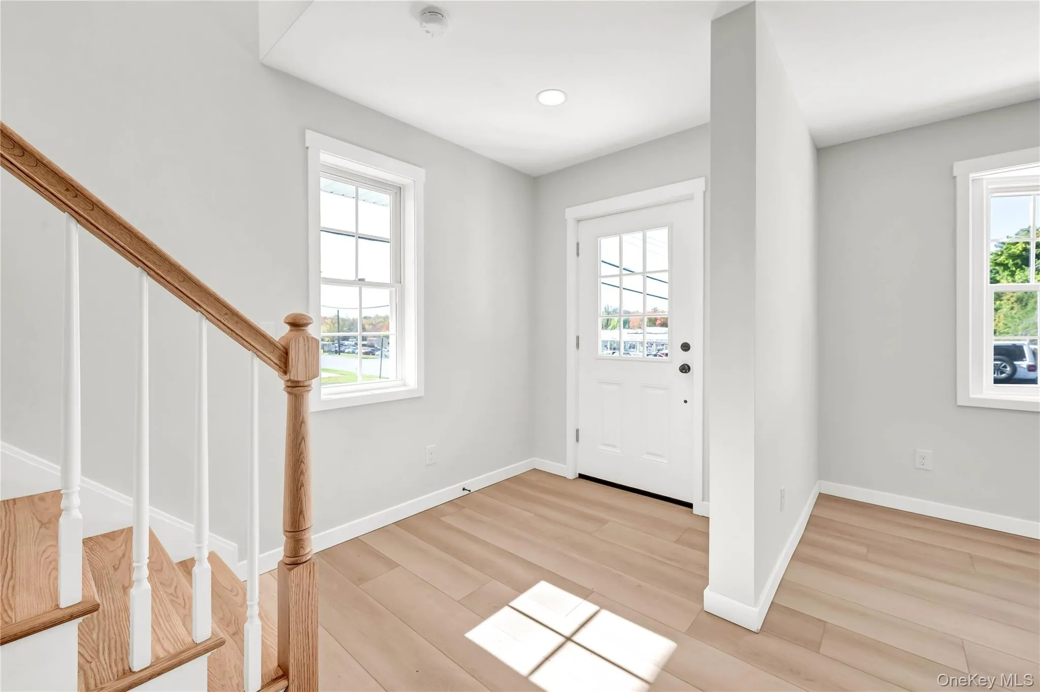 Entrance foyer featuring light wood finished floors, stairway, plenty of natural light, and recessed lighting Entrance foyer featuring light wood finished floors, stairway, plenty of natural light, and recessed lighting