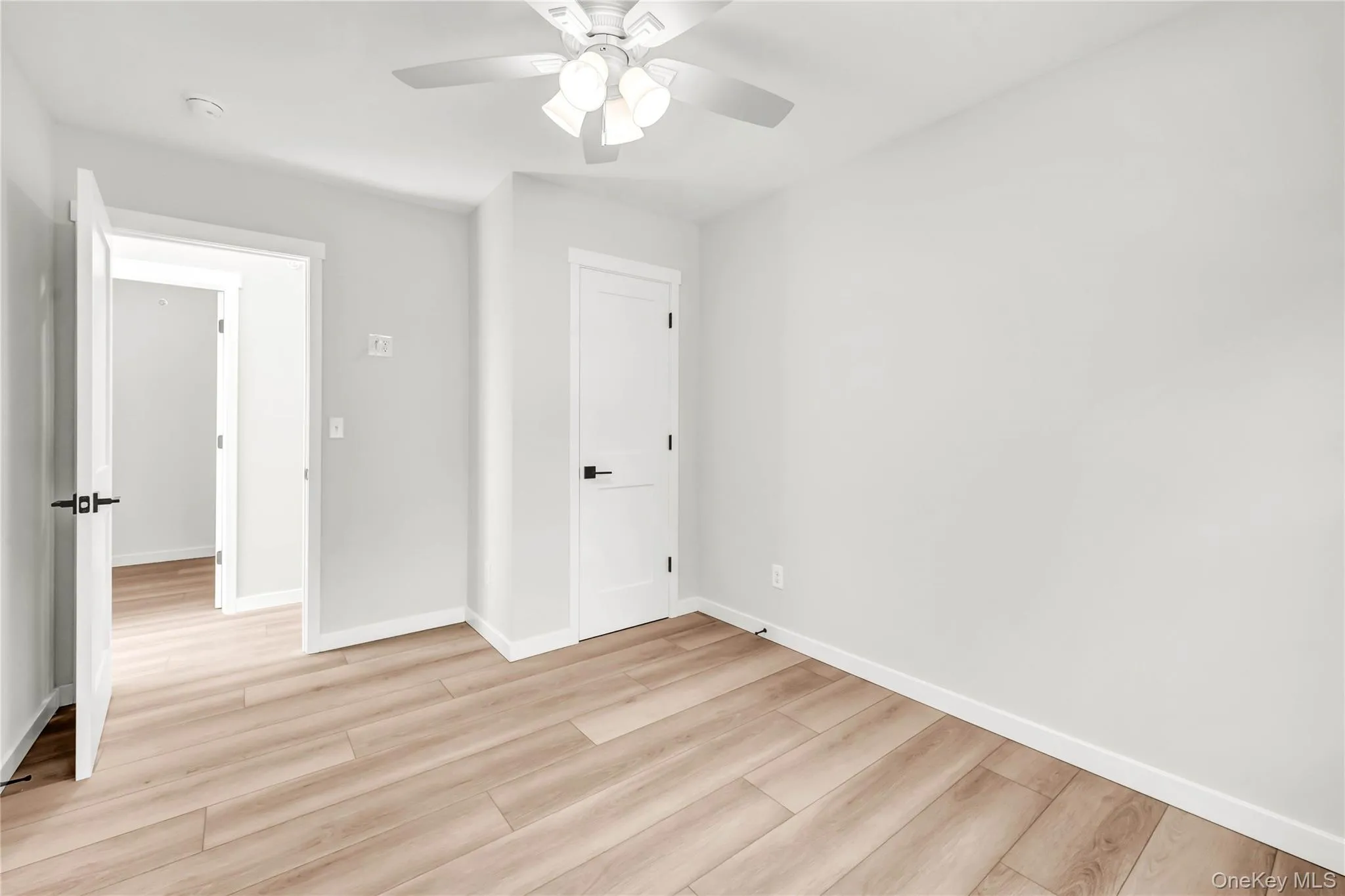 Unfurnished bedroom with light wood-style flooring and ceiling fan Unfurnished bedroom with light wood-style flooring and ceiling fan