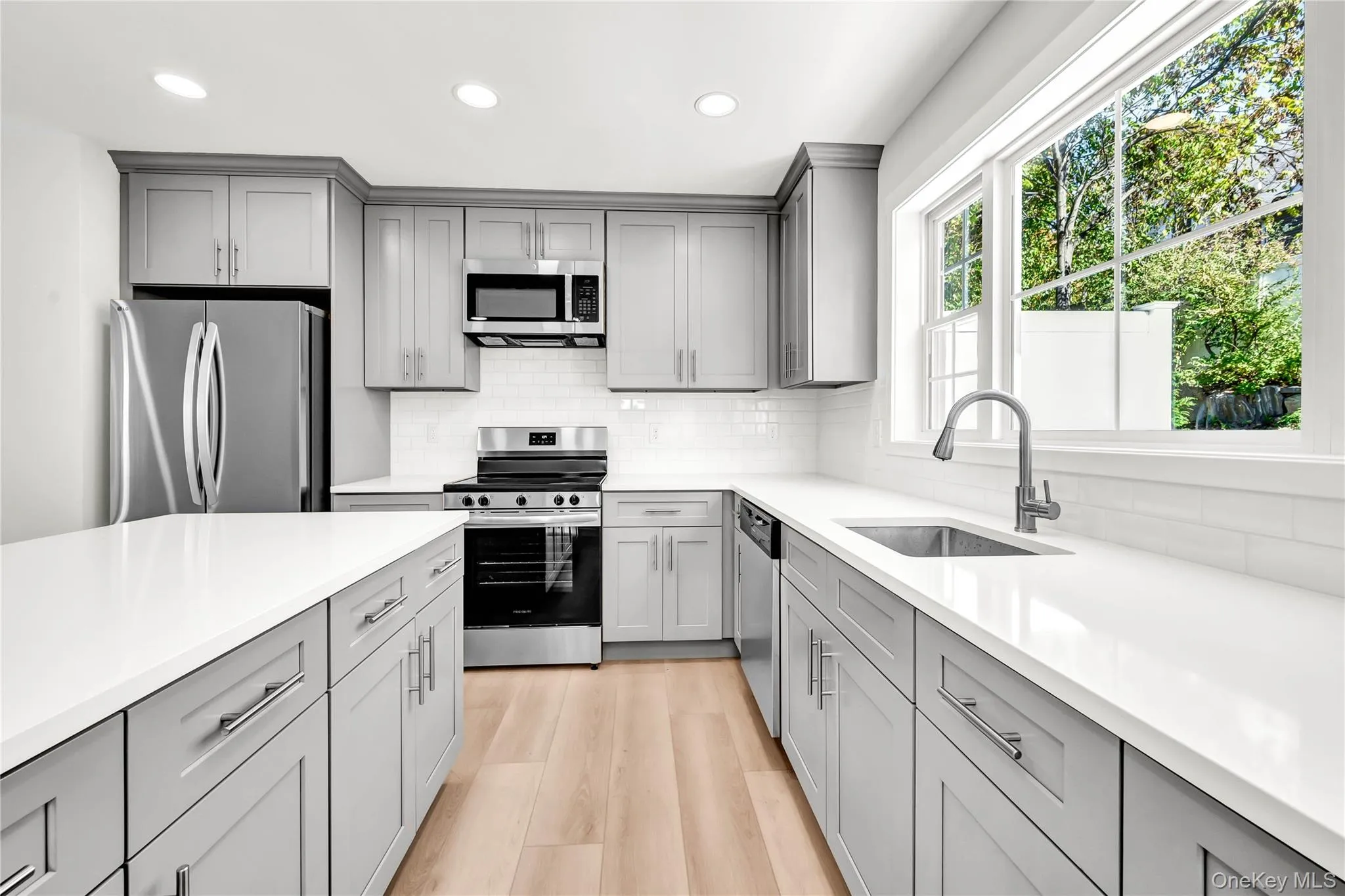 Kitchen featuring gray cabinetry, appliances with stainless steel finishes, recessed lighting, and backsplash Kitchen featuring gray cabinetry, appliances with stainless steel finishes, recessed lighting, and backsplash