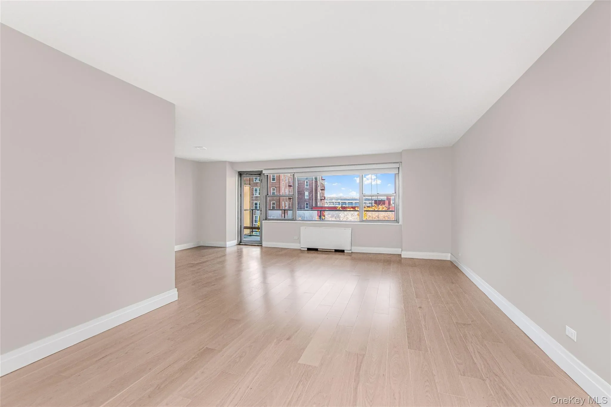 Unfurnished room with light wood-style flooring and radiator Unfurnished room with light wood-style flooring and radiator