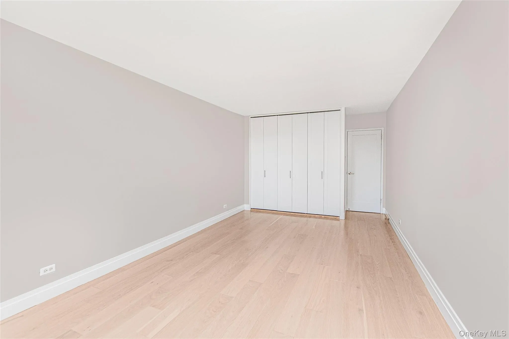 Unfurnished bedroom with light wood finished floors and a closet Unfurnished bedroom with light wood finished floors and a closet