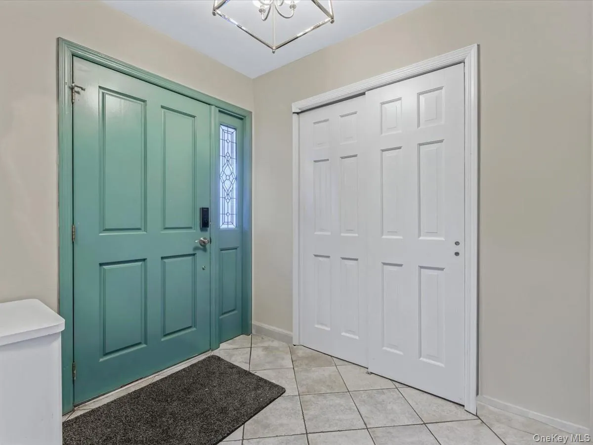 Entrance foyer featuring light tile patterned floors and a chandelier Entrance foyer featuring light tile patterned floors and a chandelier