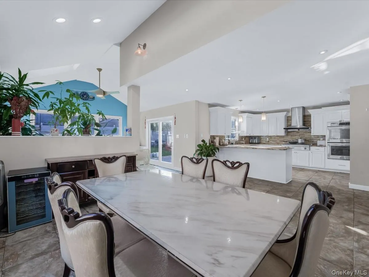 Dining space with lofted ceiling, recessed lighting, and wine cooler Dining space with lofted ceiling, recessed lighting, and wine cooler