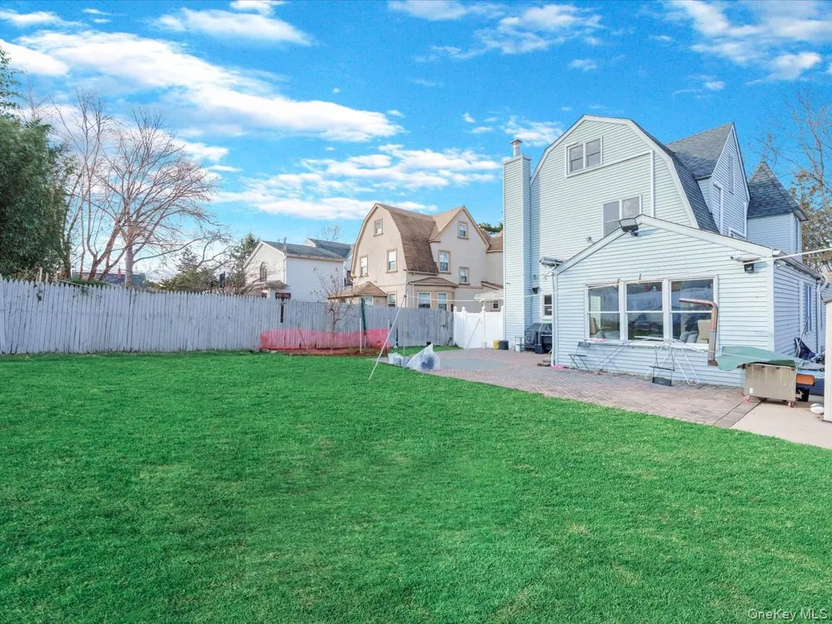 Back of property with a gambrel roof, a patio, roof with shingles, and a residential view Back of property with a gambrel roof, a patio, roof with shingles, and a residential view