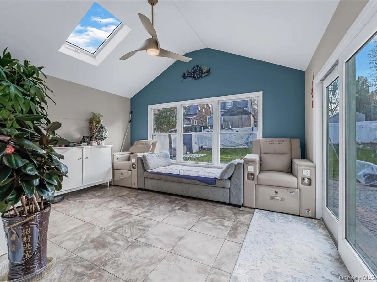 Bedroom featuring a skylight, access to exterior, lofted ceiling, and ceiling fan Bedroom featuring a skylight, access to exterior, lofted ceiling, and ceiling fan