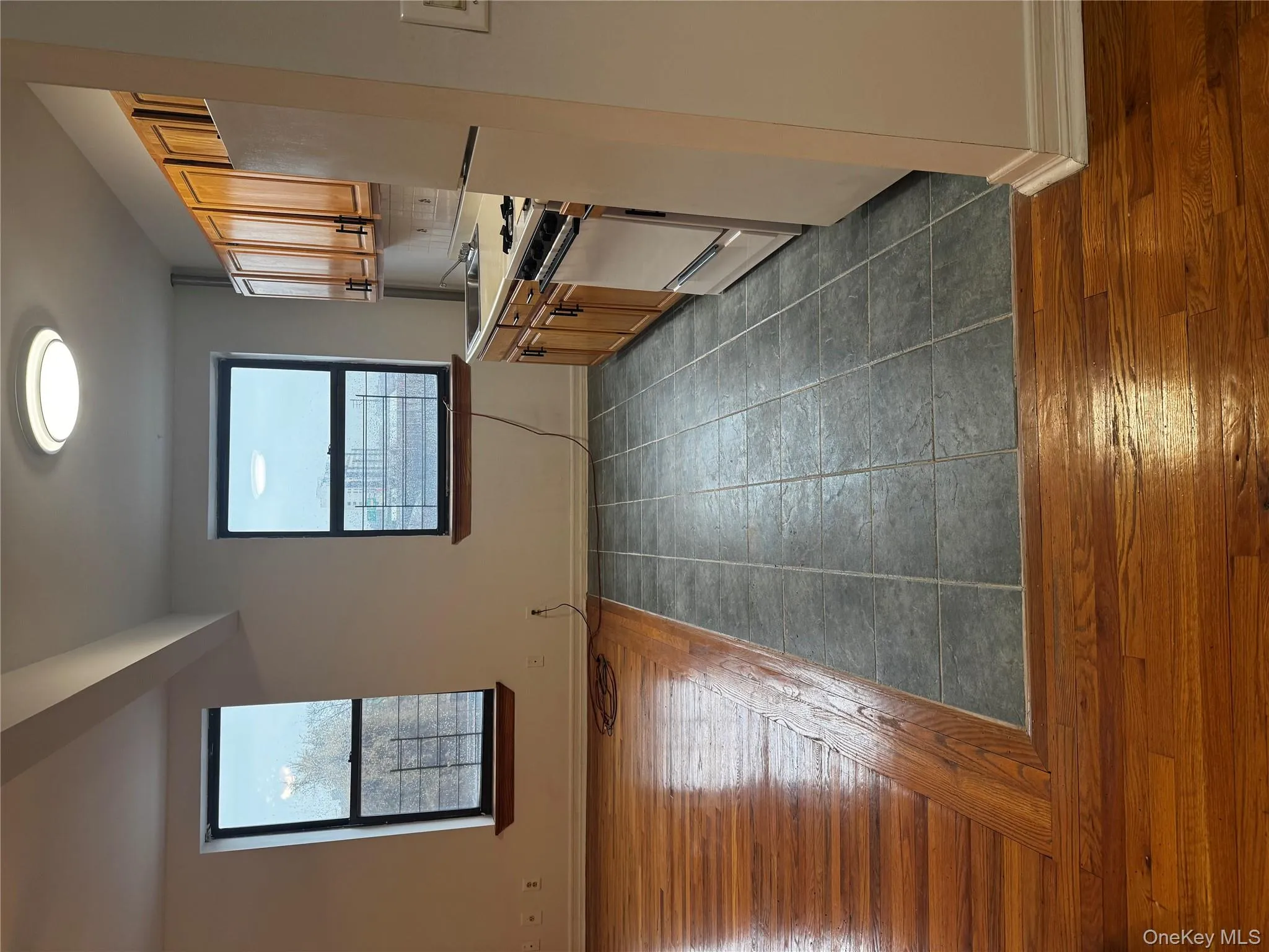 Kitchen with dark wood-style floors, black refrigerator, range, and brown cabinets Kitchen with dark wood-style floors, black refrigerator, range, and brown cabinets