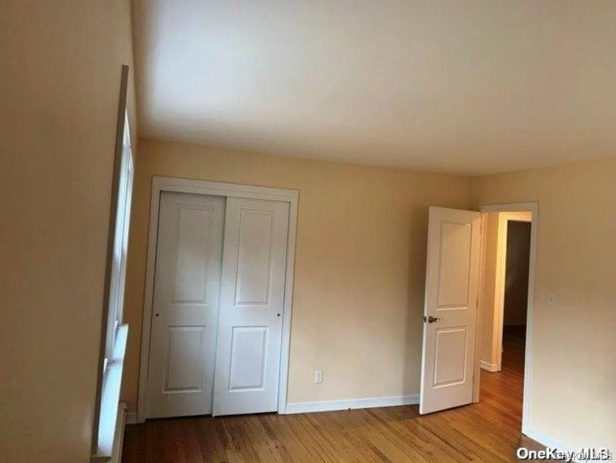 Unfurnished bedroom with wood finished floors and a closet Unfurnished bedroom with wood finished floors and a closet