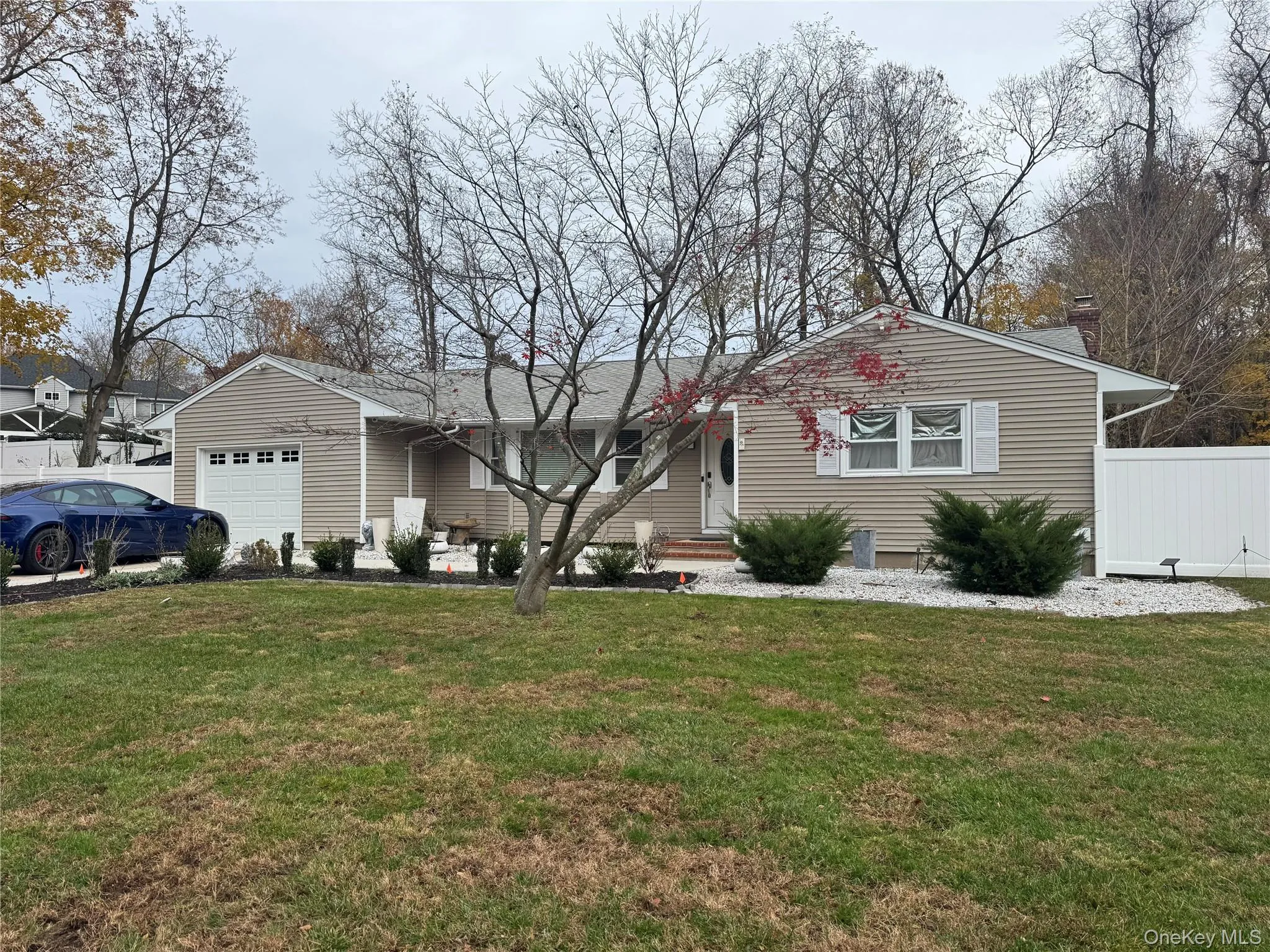 Ranch-style home featuring a garage and a chimney Ranch-style home featuring a garage and a chimney