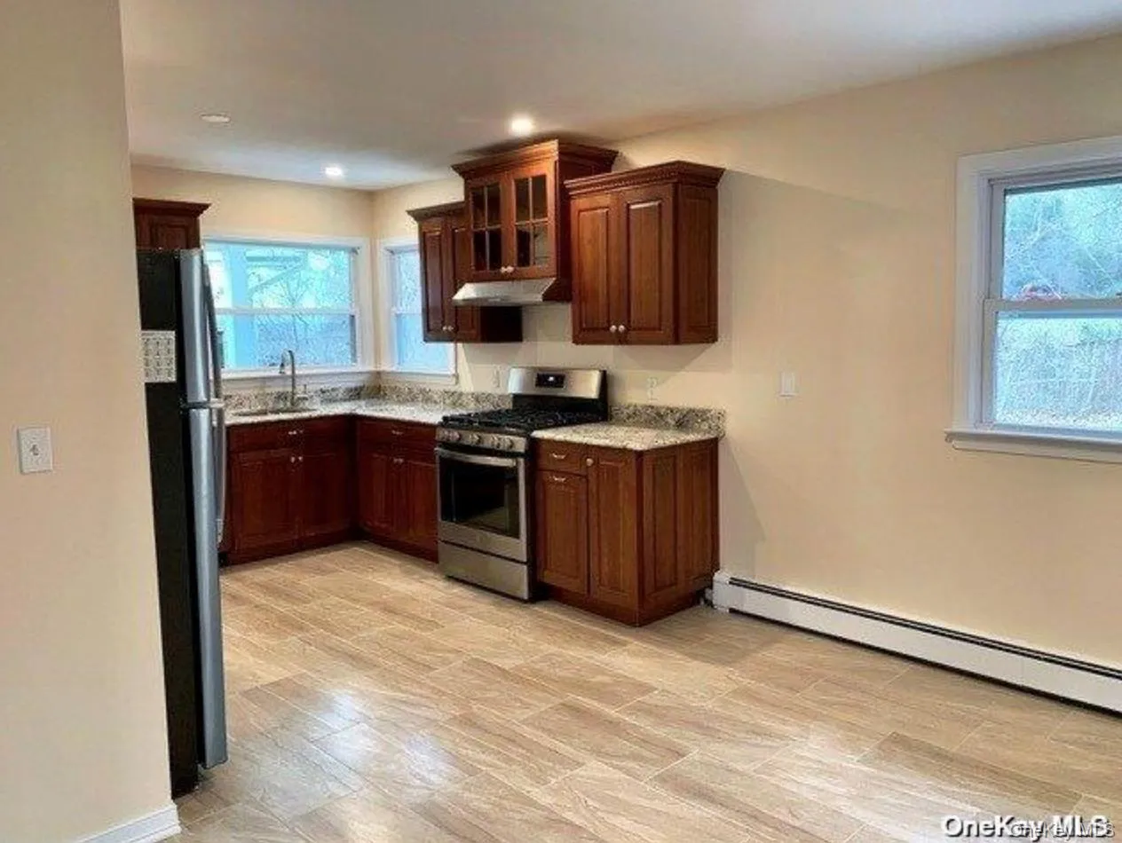 Kitchen featuring gas stove, healthy amount of natural light, glass insert cabinets, and freestanding refrigerator Kitchen featuring gas stove, healthy amount of natural light, glass insert cabinets, and freestanding refrigerator