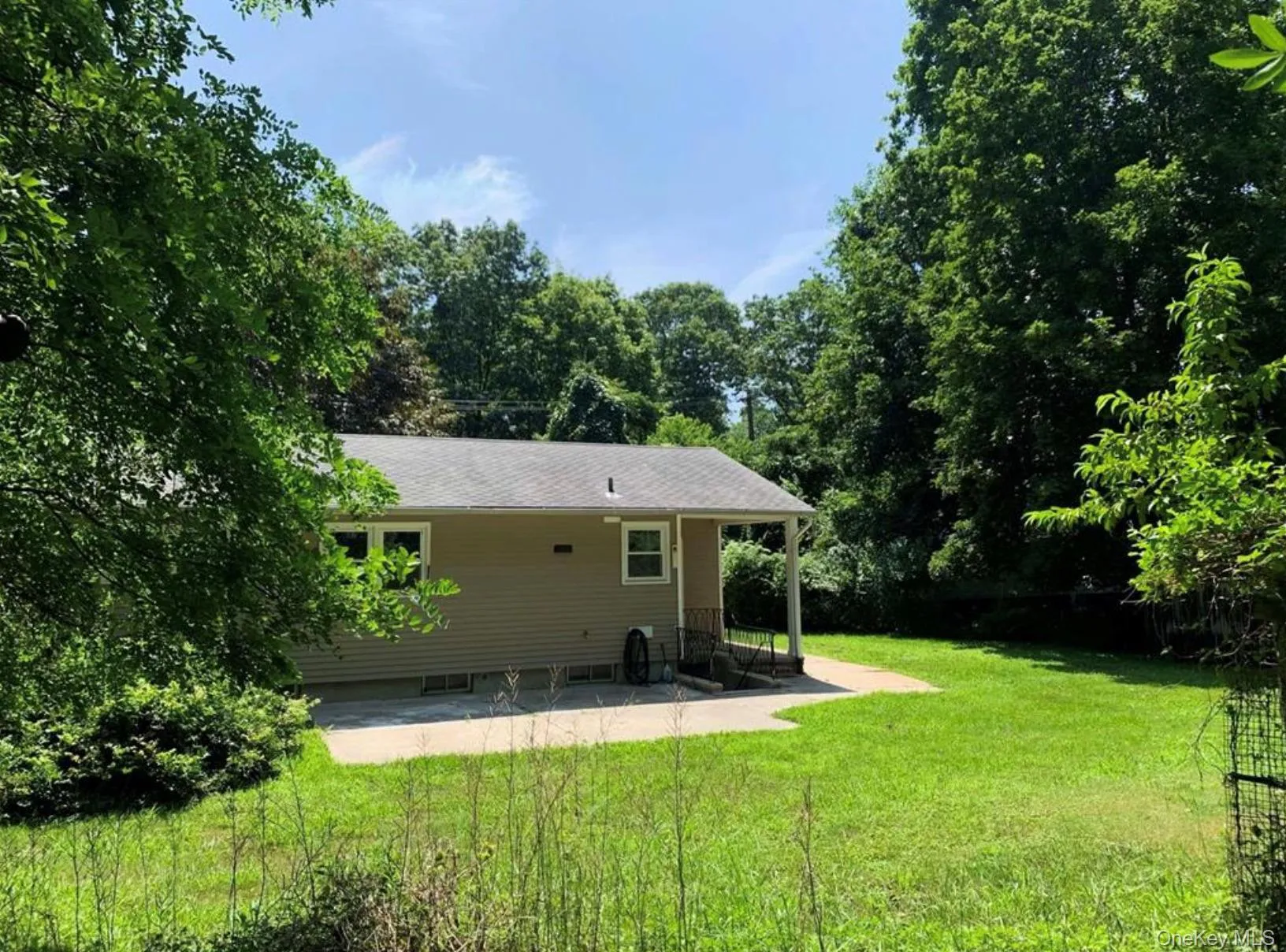 Rear view of property with a patio and a lawn Rear view of property with a patio and a lawn