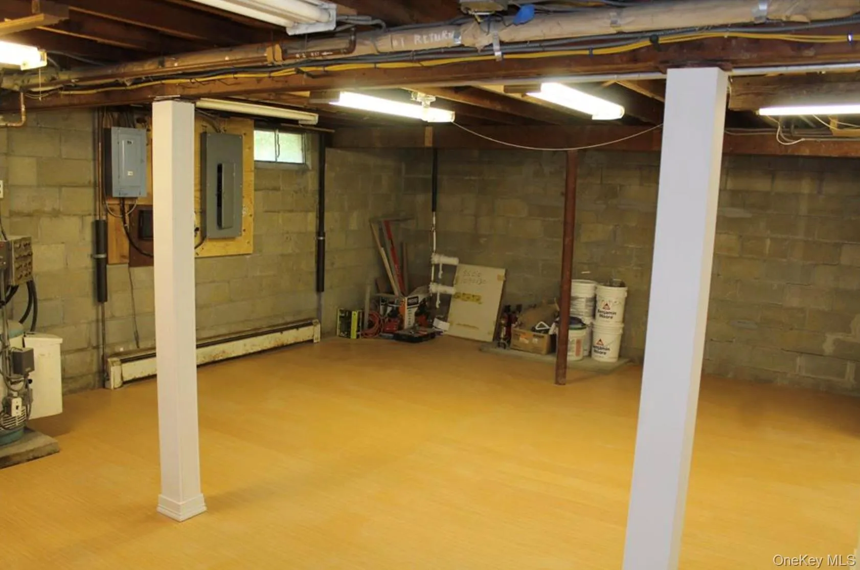 Below grade area with a baseboard radiator and electric panel Below grade area with a baseboard radiator and electric panel