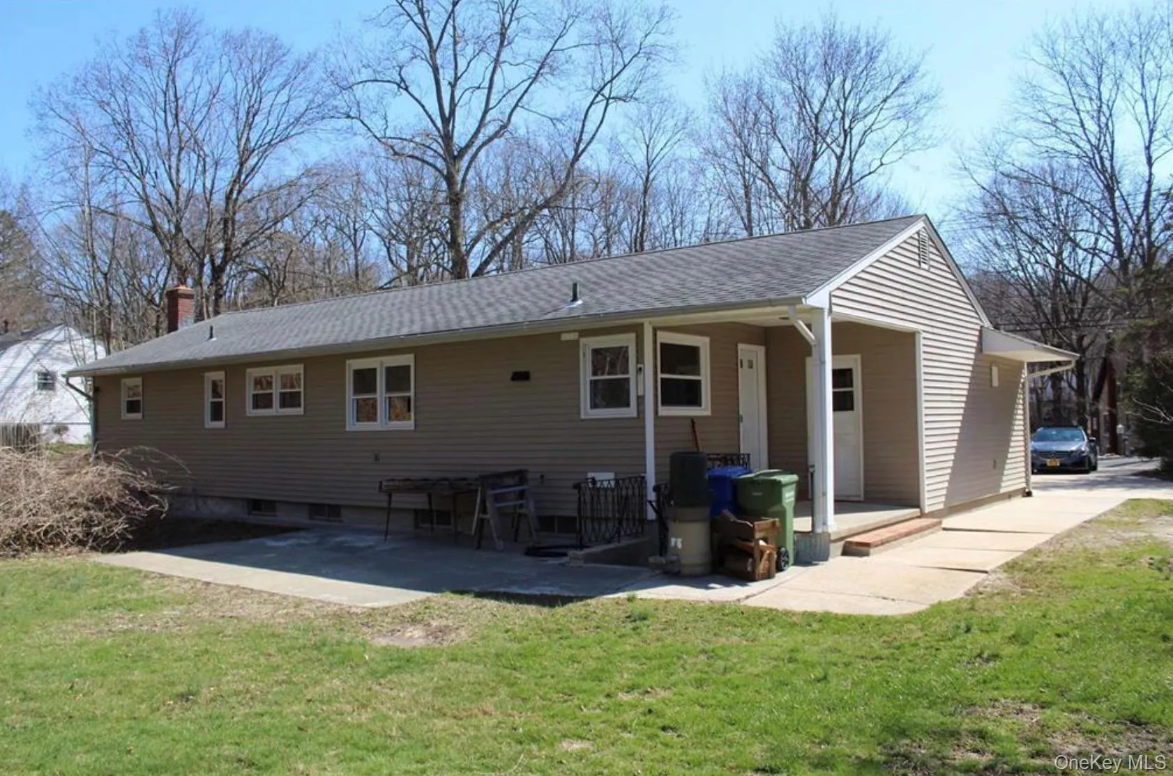 Rear view of property with a lawn, a chimney, covered porch, and roof with shingles Rear view of property with a lawn, a chimney, covered porch, and roof with shingles