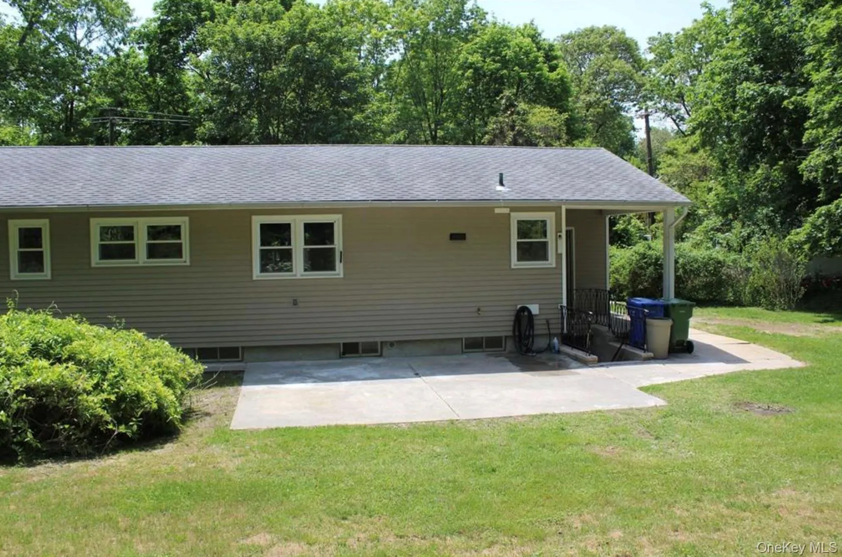 Rear view of property featuring a patio area, a lawn, and roof with shingles Rear view of property featuring a patio area, a lawn, and roof with shingles