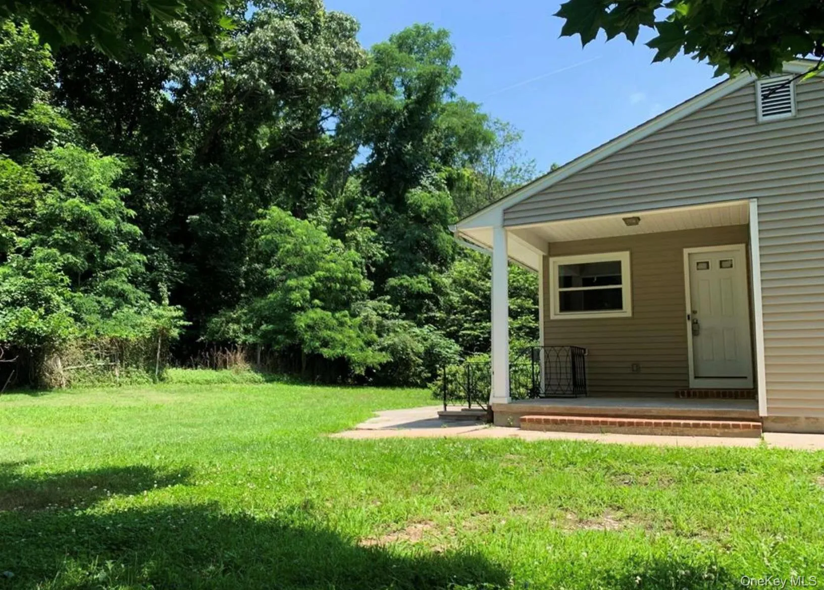 View of green lawn with a porch View of green lawn with a porch