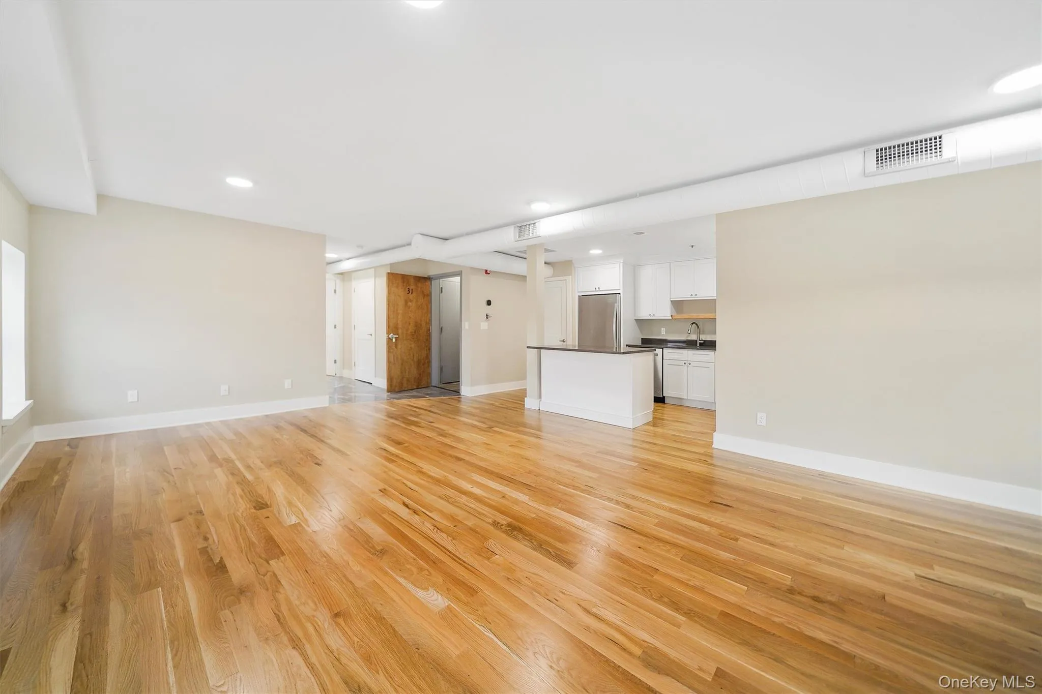 Unfurnished living room featuring light wood-style flooring and recessed lighting Unfurnished living room featuring light wood-style flooring and recessed lighting