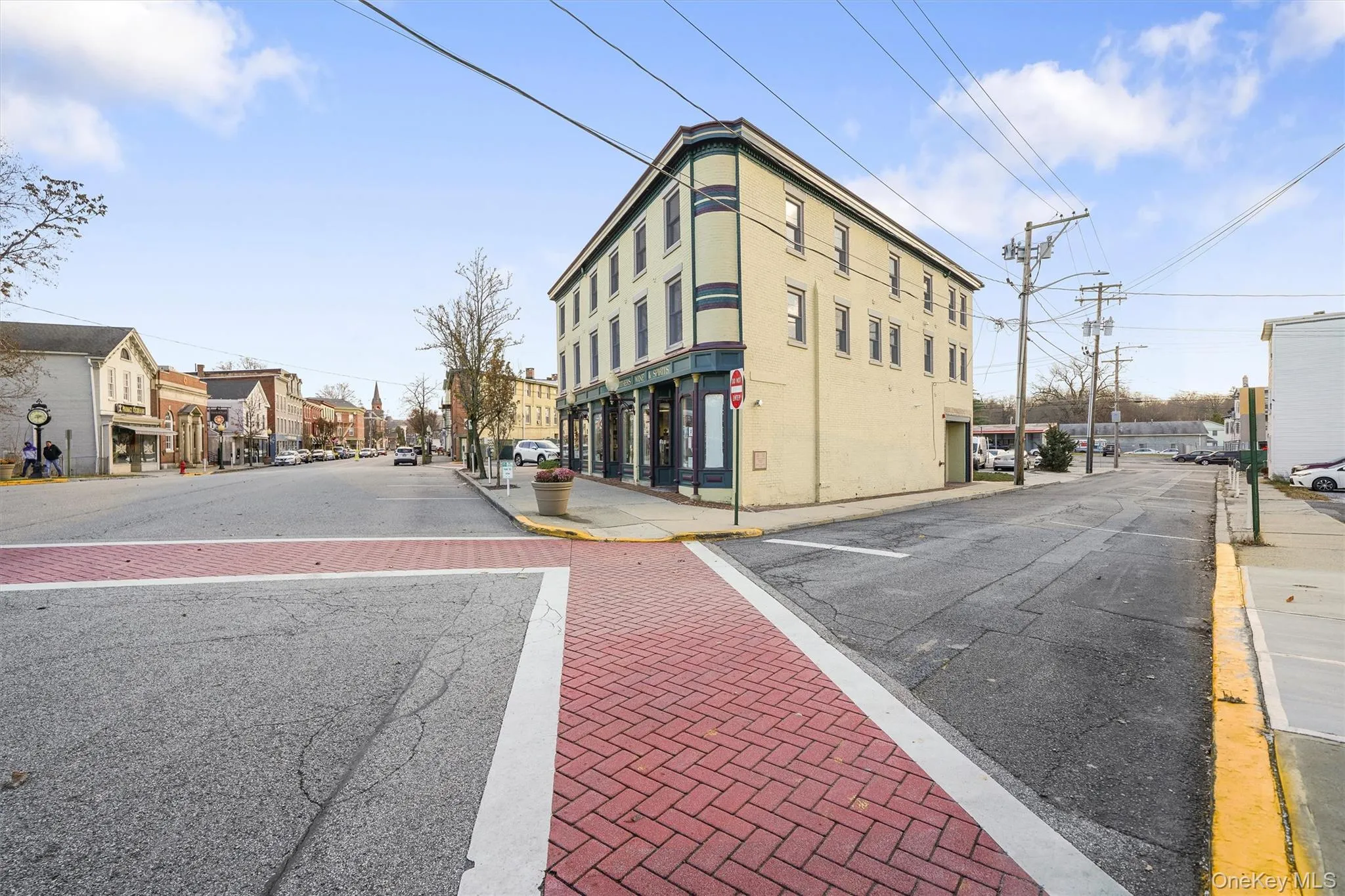 View of asphalt street featuring sidewalks, curbs, street lights, and traffic signs View of asphalt street featuring sidewalks, curbs, street lights, and traffic signs