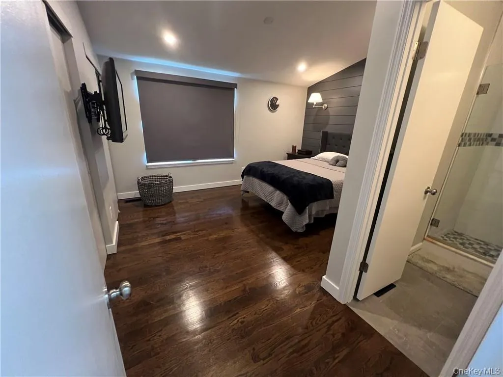 Bedroom featuring vaulted ceiling and dark hardwood / wood-style flooring Bedroom featuring vaulted ceiling and dark hardwood / wood-style flooring