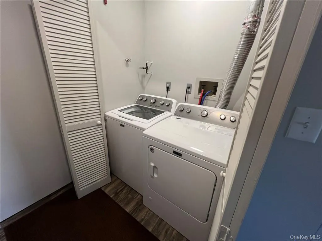 Laundry area with dark wood-type flooring and washing machine and dryer Laundry area with dark wood-type flooring and washing machine and dryer