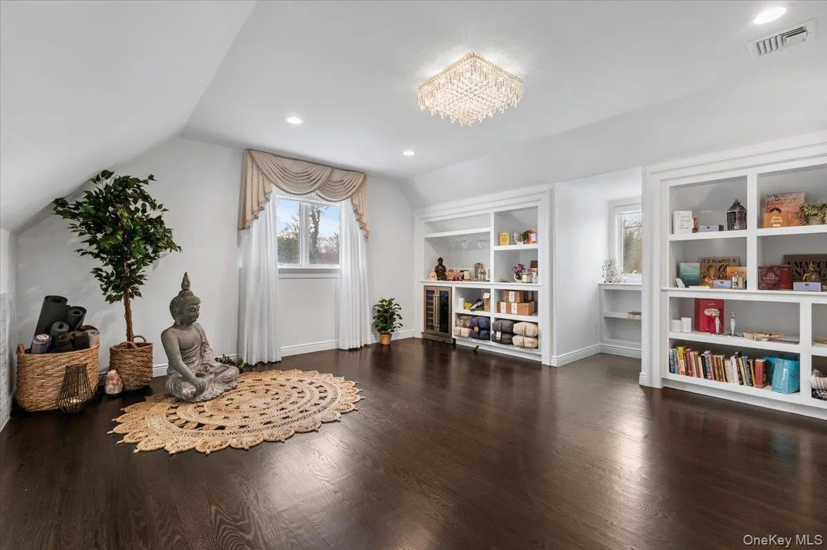 Sitting room featuring lofted ceiling, dark wood-style floors, recessed lighting, a chandelier, and built in features Sitting room featuring lofted ceiling, dark wood-style floors, recessed lighting, a chandelier, and built in features