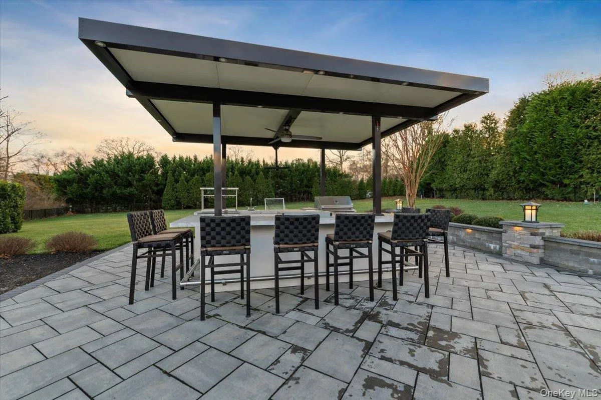 Patio terrace at dusk featuring a ceiling fan, a yard, a patio, and an outdoor kitchen Patio terrace at dusk featuring a ceiling fan, a yard, a patio, and an outdoor kitchen