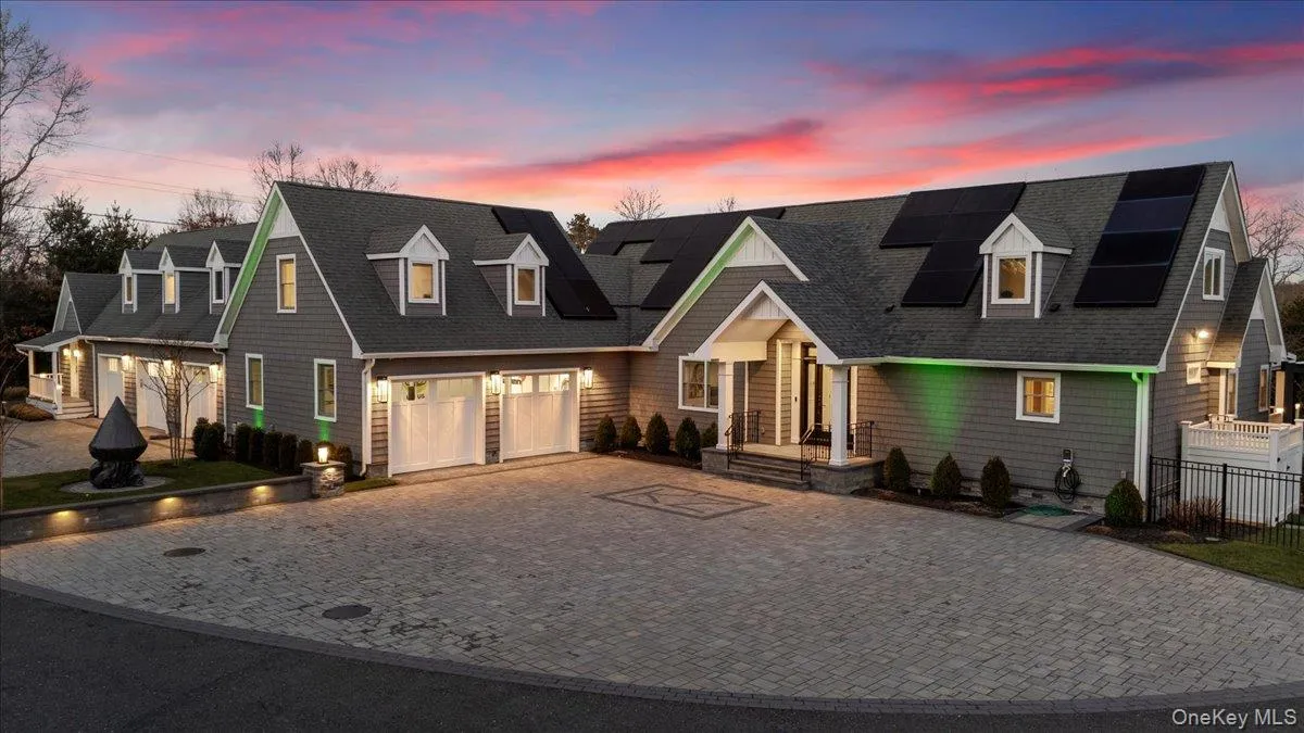View of front of property featuring decorative driveway, a shingled roof, a garage, and roof mounted solar panels View of front of property featuring decorative driveway, a shingled roof, a garage, and roof mounted solar panels
