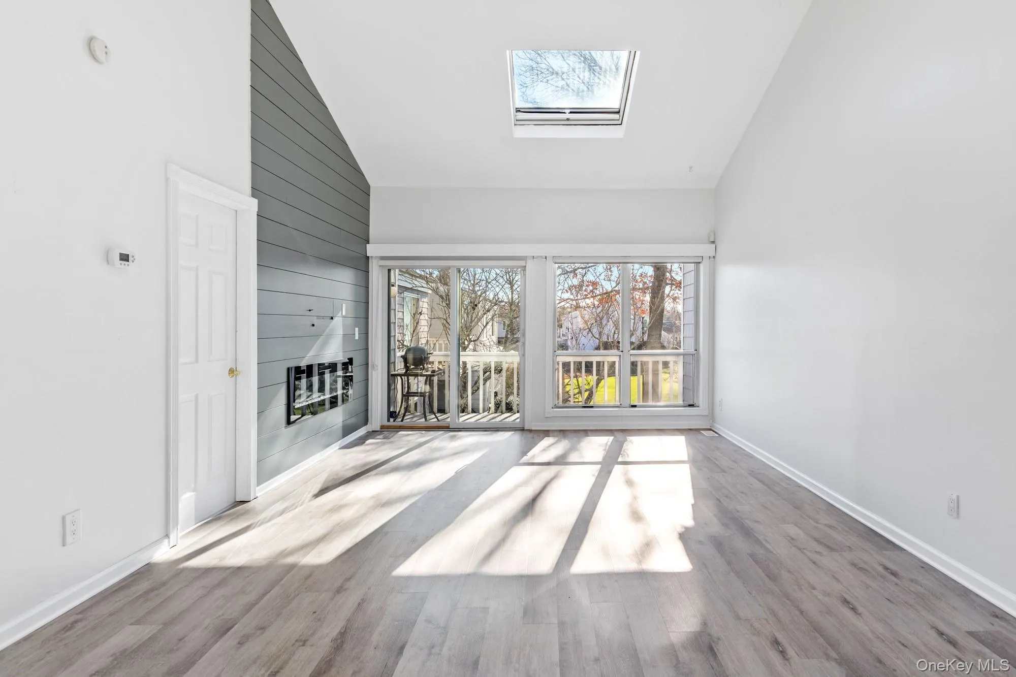 living room with a skylight, vaulted ceiling, and gas fireplace. living room with a skylight, vaulted ceiling, and gas fireplace.