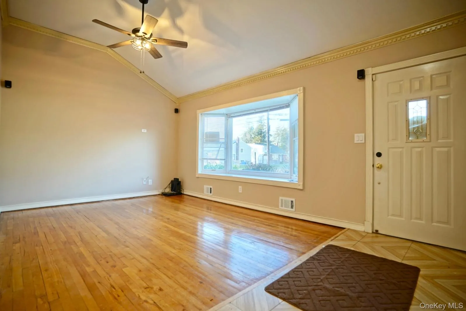 Foyer with light wood-style floors, vaulted ceiling, a ceiling fan, and crown molding Foyer with light wood-style floors, vaulted ceiling, a ceiling fan, and crown molding