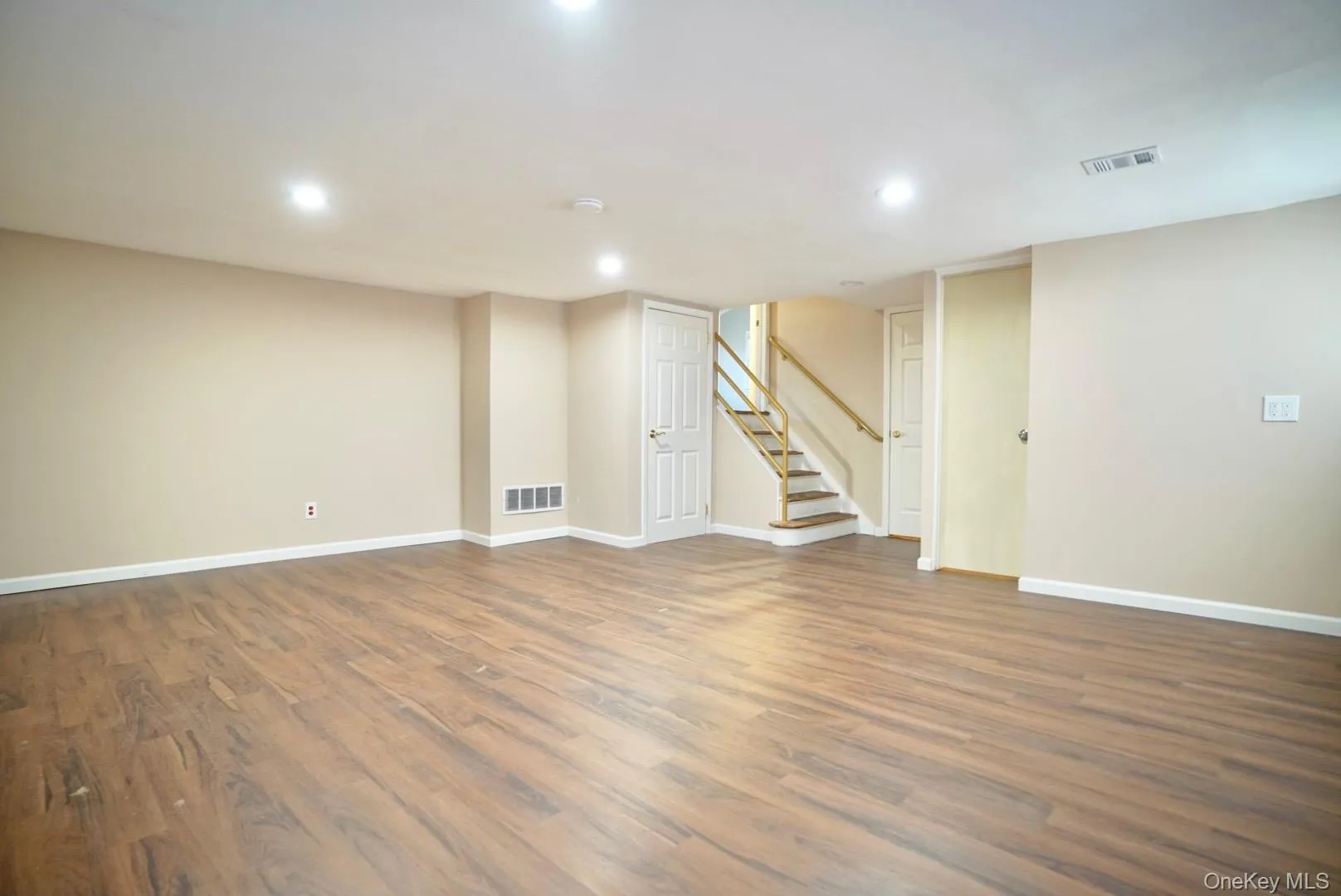 Finished below grade area featuring stairs, dark wood-type flooring, and recessed lighting Finished below grade area featuring stairs, dark wood-type flooring, and recessed lighting