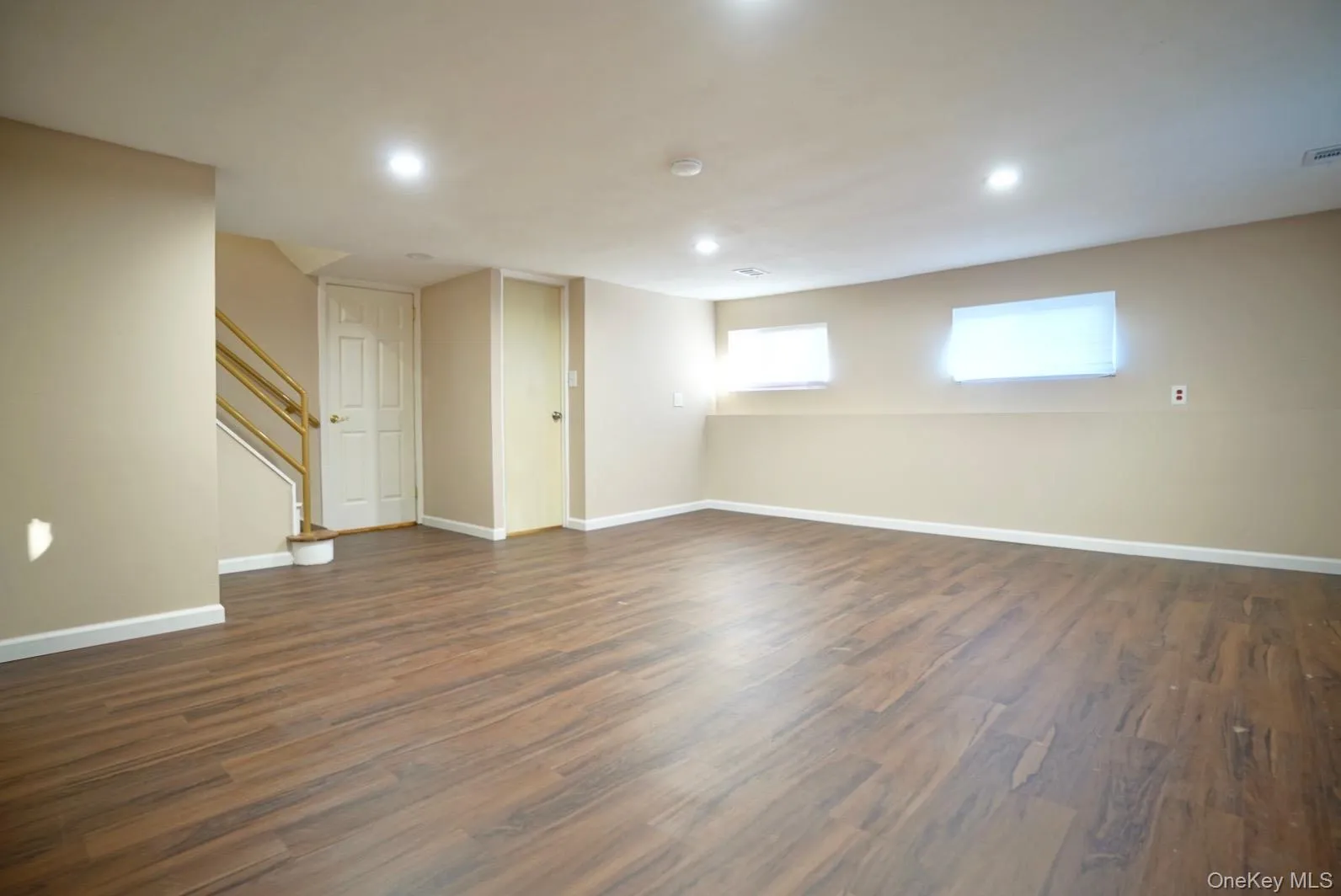 Basement featuring dark wood-style floors, stairs, and recessed lighting Basement featuring dark wood-style floors, stairs, and recessed lighting