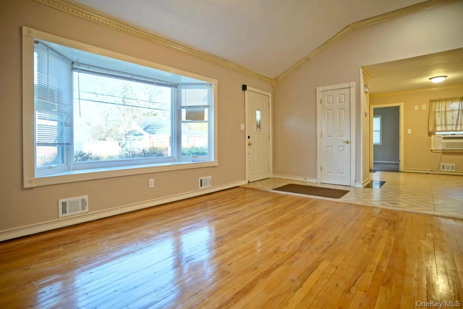 Entrance foyer with light wood-style flooring, lofted ceiling, and ornamental molding Entrance foyer with light wood-style flooring, lofted ceiling, and ornamental molding
